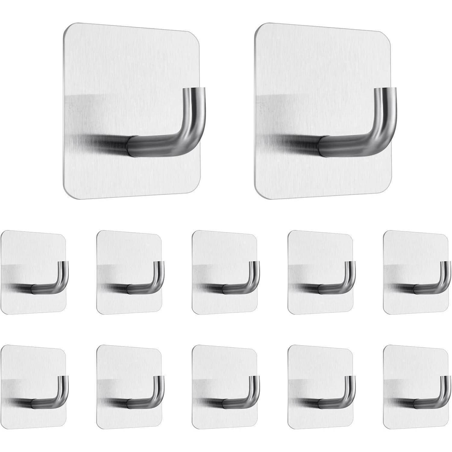 Ein Set aus 12 Edelstahl-Klebehaken zur Wandmontage. Jeder Haken hat eine elegante silberne Oberfläche und ist für das sichere Aufhängen von Gegenständen konzipiert.