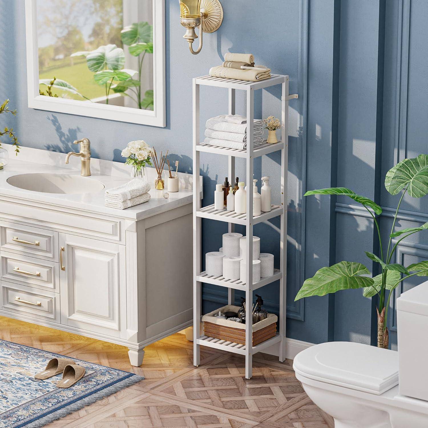 Ein heller Badezimmer zeigt ein weißes Waschtisch mit Goldarmaturen, einen Spiegel, ein hohes weißes Regalregal mit Toilettenartikeln und Topfpflanzen.