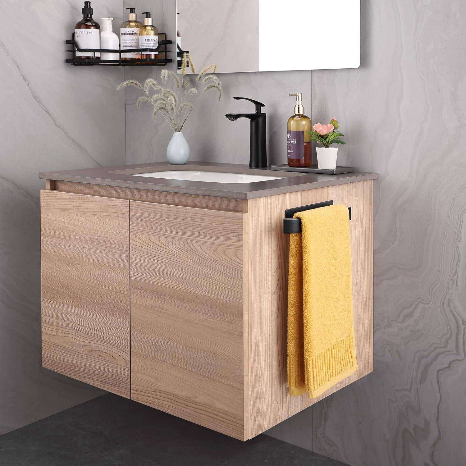 Ein modernes Badezimmer-Waschtisch mit einem Holzschrank, einem Wasserhahn auf einer grauen Arbeitsplatte und einem gelben Handtuch an der Seite.