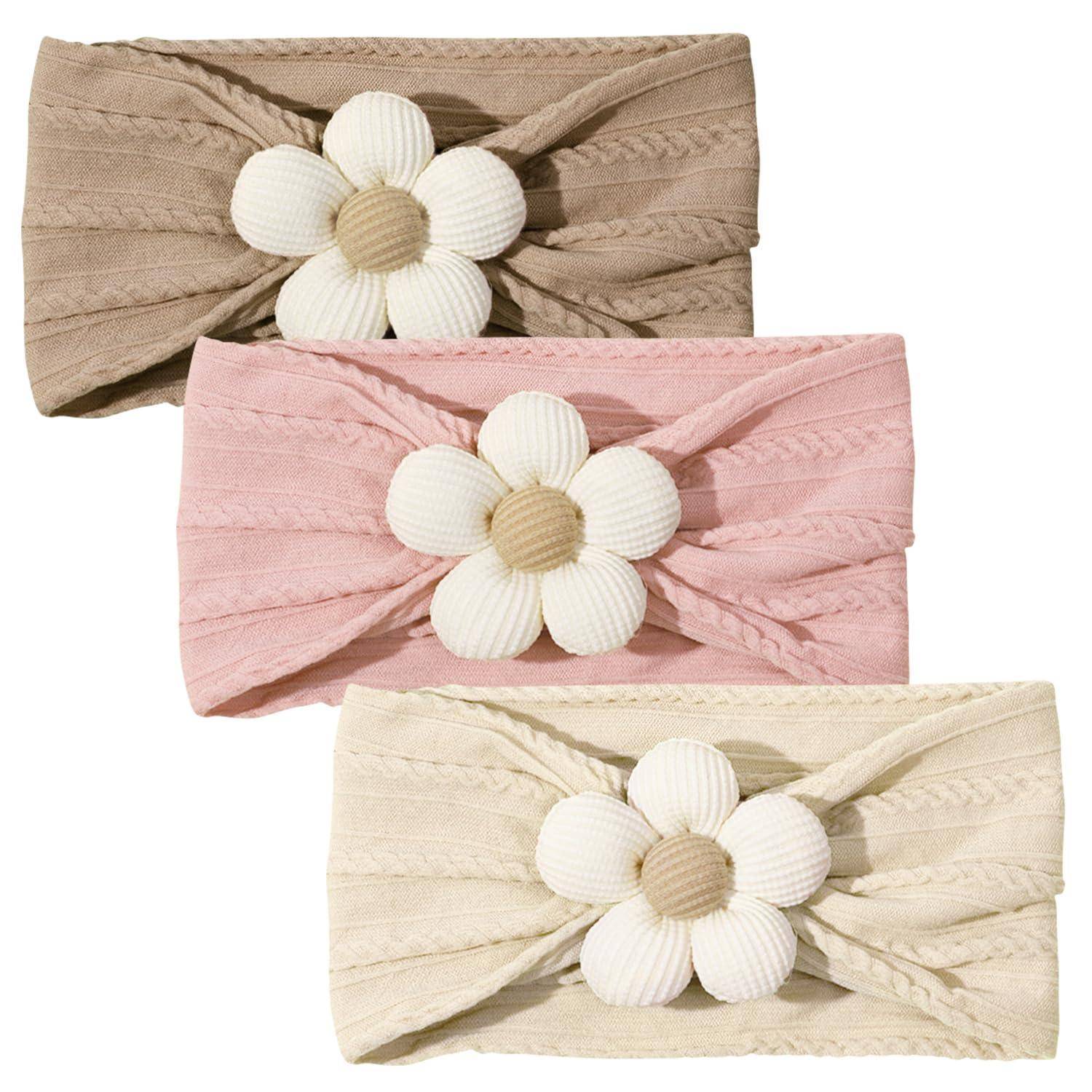 Drei Haarreife mit großen weißen Blumen auf strukturiertem Stoff: einer in Beige, einer in Rosa und einer in Creme, vertikal übereinander angeordnet.