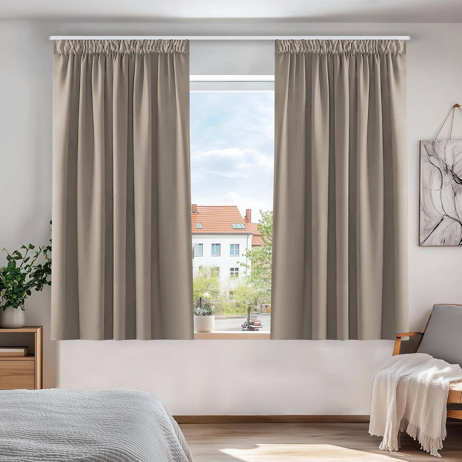 Ein Fenster mit hellbeigen Vorhängen, die teilweise geöffnet sind und einen Blick auf einen klaren Himmel und Dächer freigeben. Eine kleine Pflanze und abstrakte Kunst schmücken den Raum.