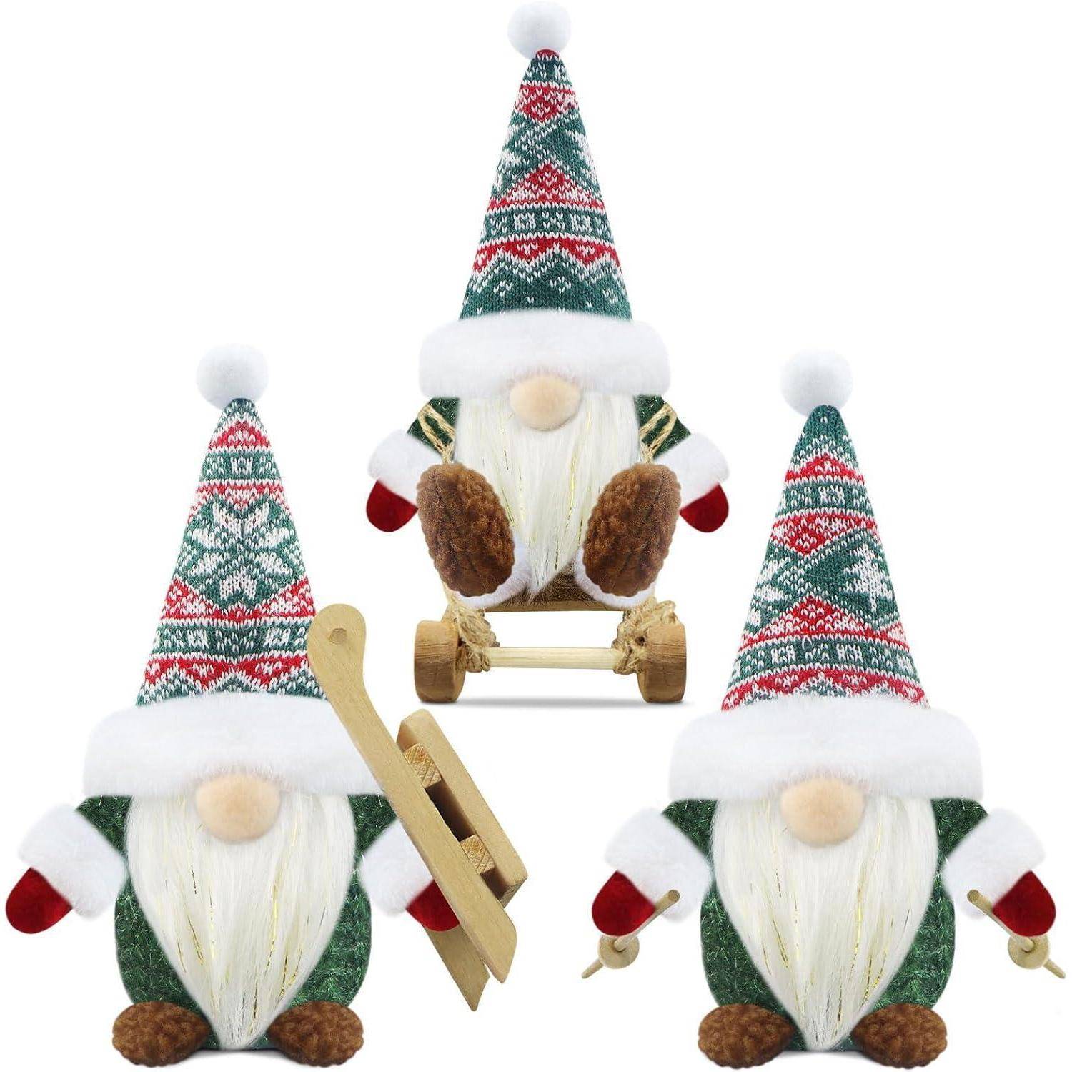 Drei Gnome mit gemusterten Hüten und Bärten; einer fährt Schlitten und hält dabei zwei goldene Skier.