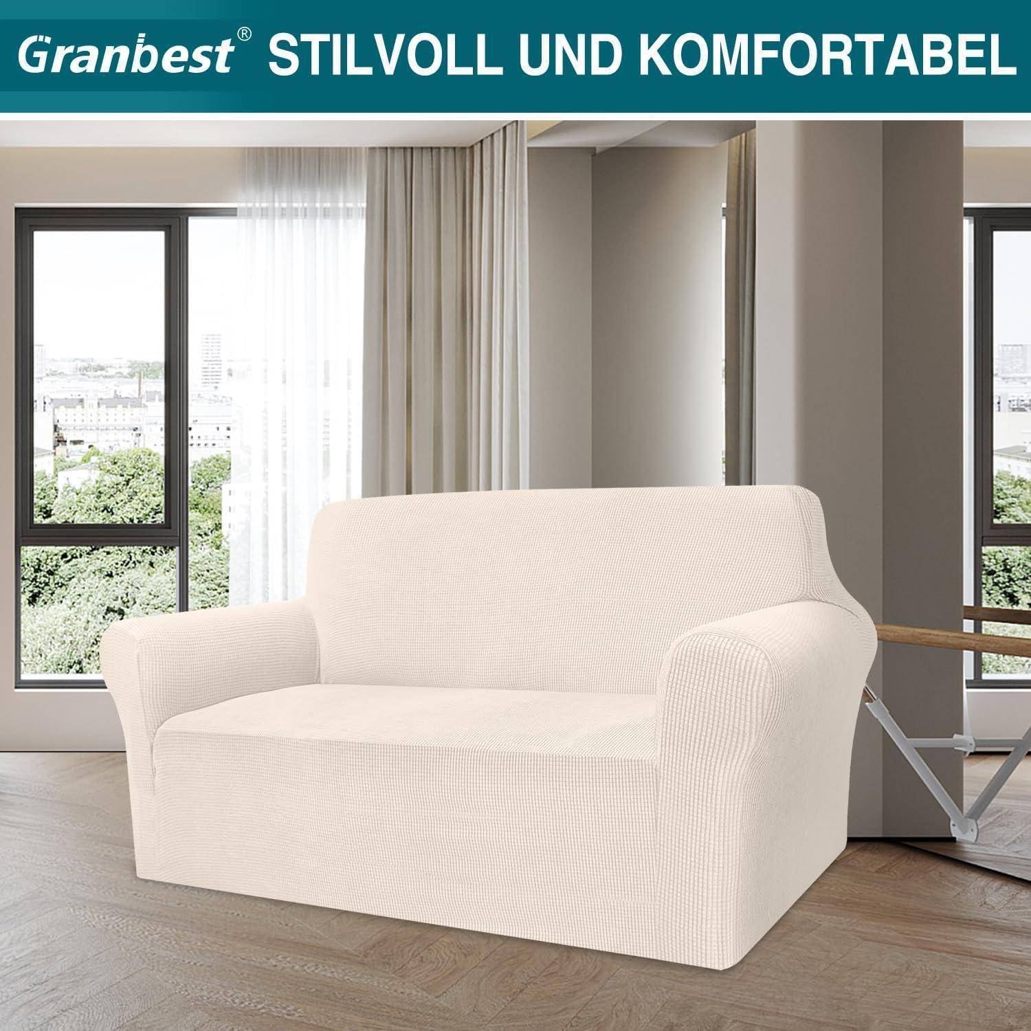 Ein beiger Sofa mit einem passenden Bezug steht in einem modernen Wohnzimmer mit großen Fenstern, über dem 'Granbest Stilvoll und Komfortabel' zu lesen ist.