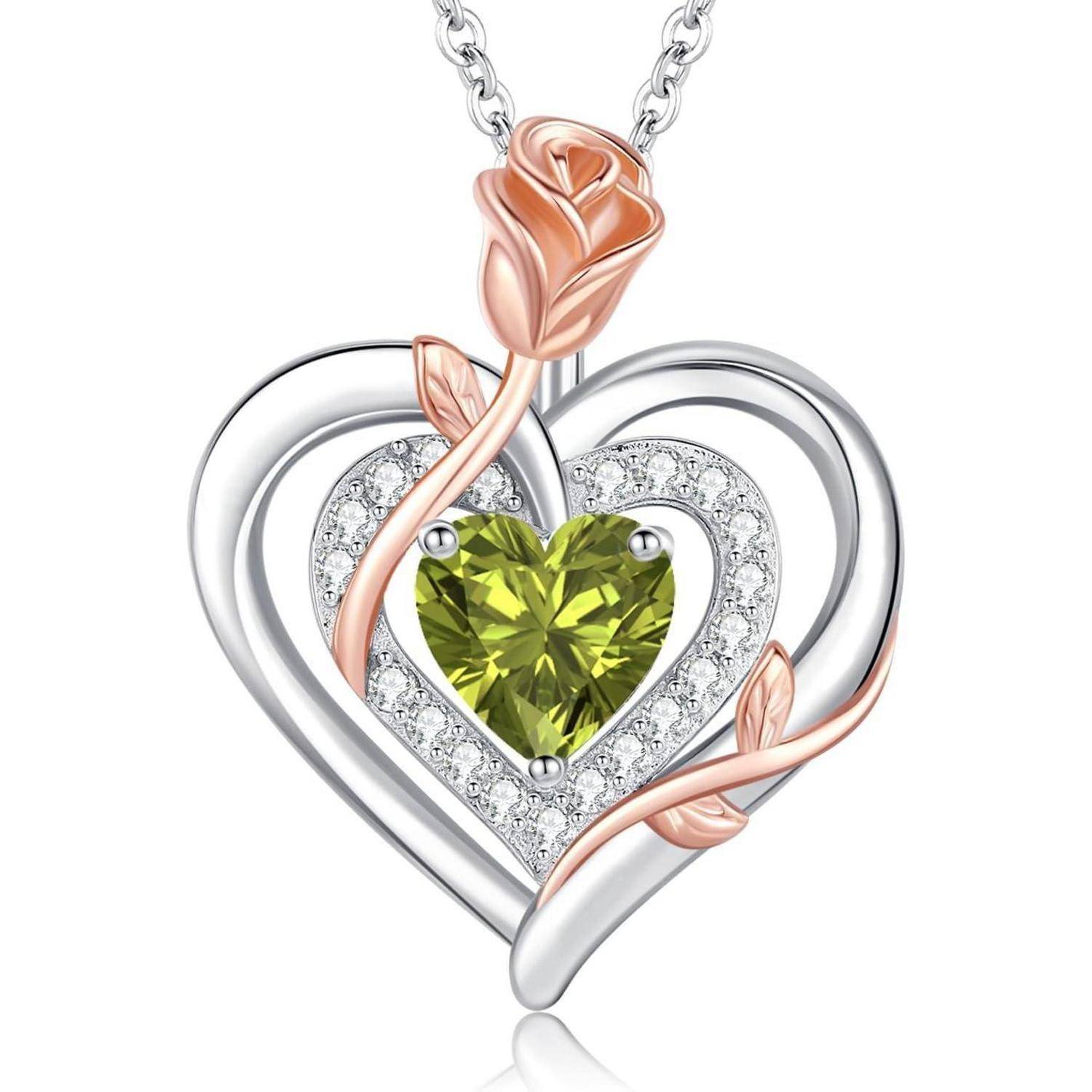 Ein herzförmiger Anhänger mit einem Design aus Silber und Roségold, der einen grünen Herz-Edelstein in der Mitte trägt, umgeben von funkelnden Akzenten.