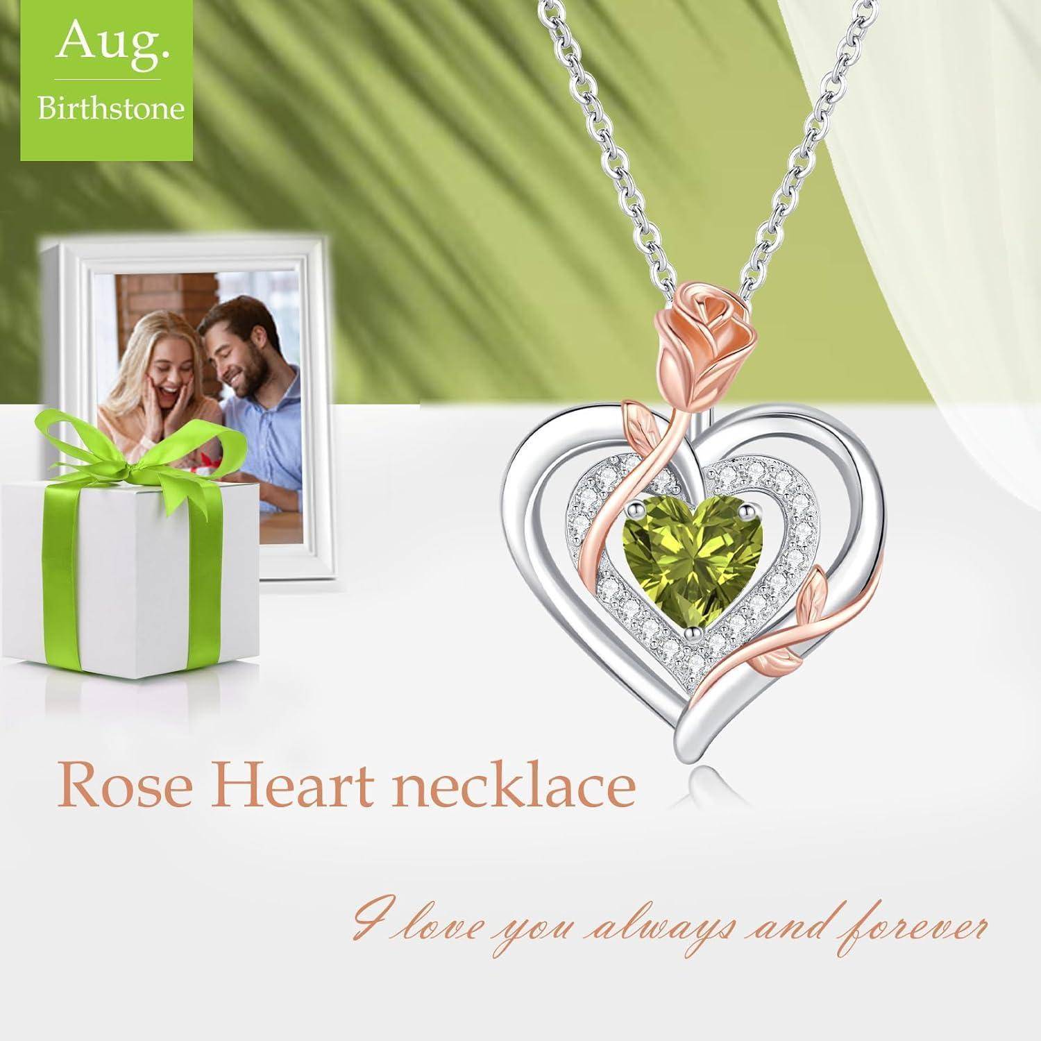 Das Bild der 'Rose Heart Halskette' zeigt einen Anhänger mit einem grünen herzförmigen Edelstein, einem Silber- und Roségold-Wirbeldesign, neben einem Pärchenfoto und einer Geschenkbox.