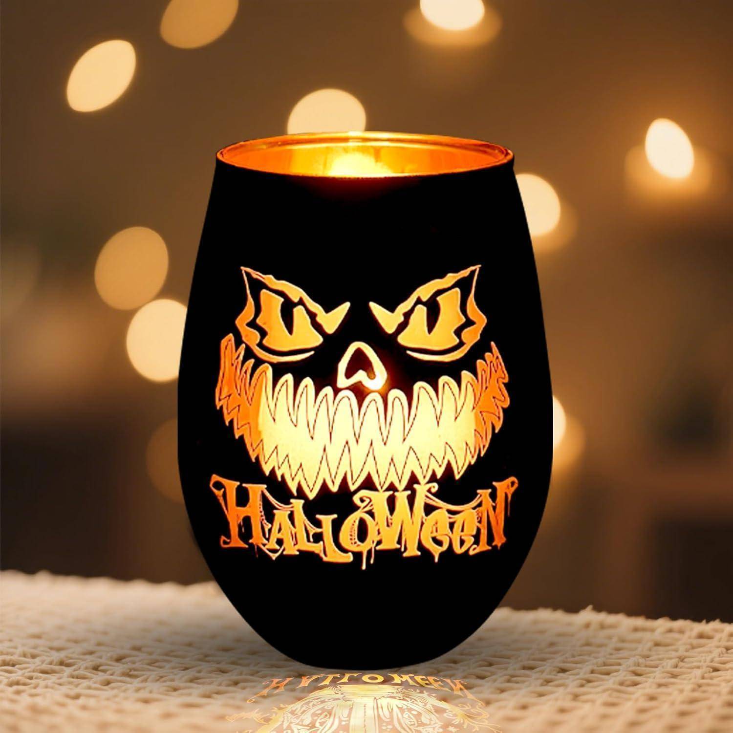 Ein schwarzer Halloween-Kerzenhalter mit einem leuchtenden, grinsenden Kürbisgesicht und dem Wort 