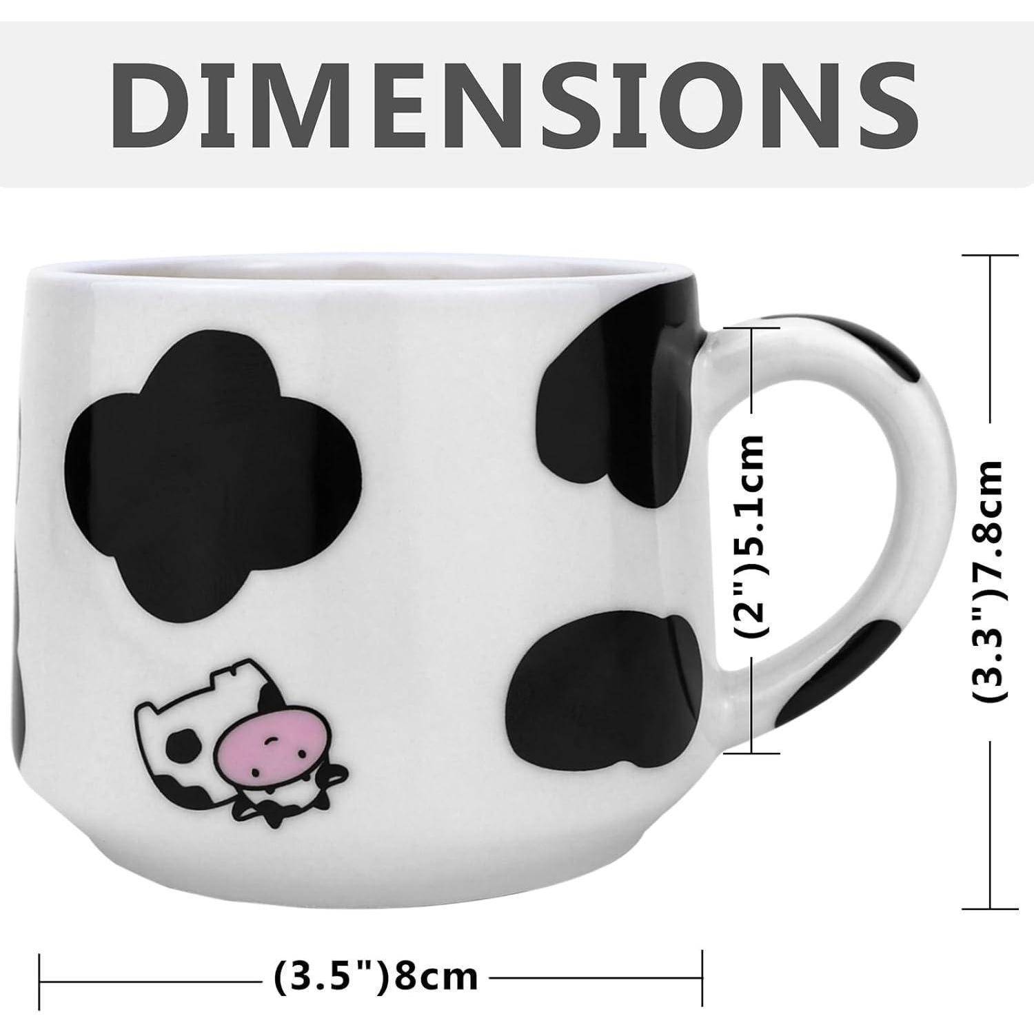 Weiße Tasse mit schwarzen Punkten und einem kleinen Kuhdesign. Abmessungen: 3,5 Zoll (8 cm) breit, 3,3 Zoll (7,8 cm) hoch, 2 Zoll (5,1 cm) Henkelgröße.