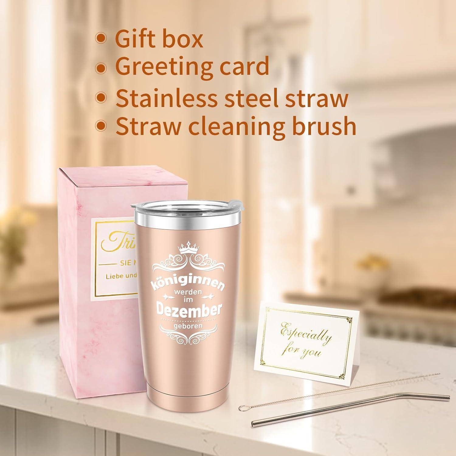 Ein Edelstahl-Tumbler mit dem Text 'Königinnen werden im Dezember geboren' neben einer rosa Geschenkbox, einer Karte, einem Strohhalm und einer Reinigungsbürste.