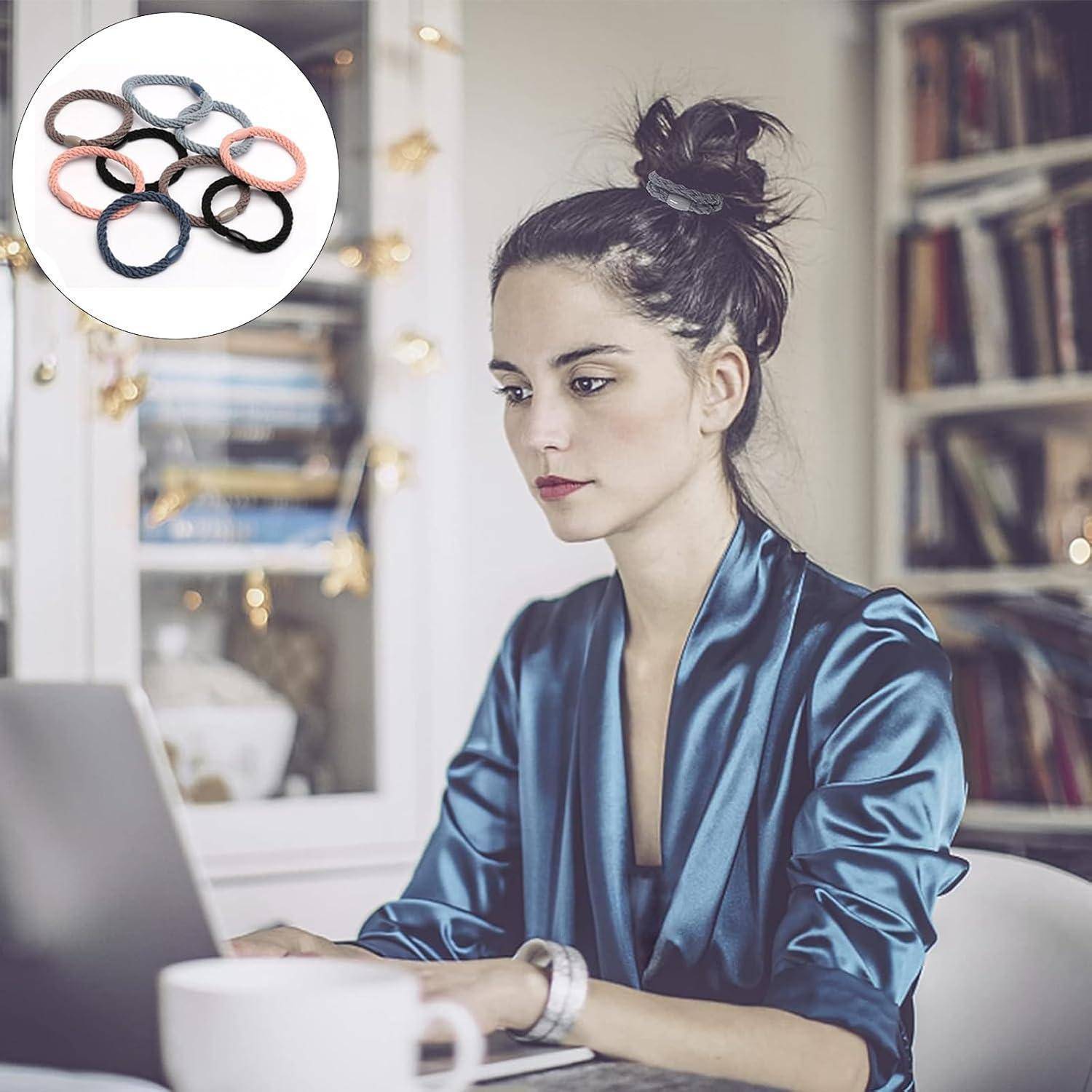Eine Frau in einem blauen Satinhemd arbeitet an einem Laptop an einem Schreibtisch. Das Einsatzbild zeigt eine Reihe bunter Haargummis. Bücherregale sind hinter ihr sichtbar.