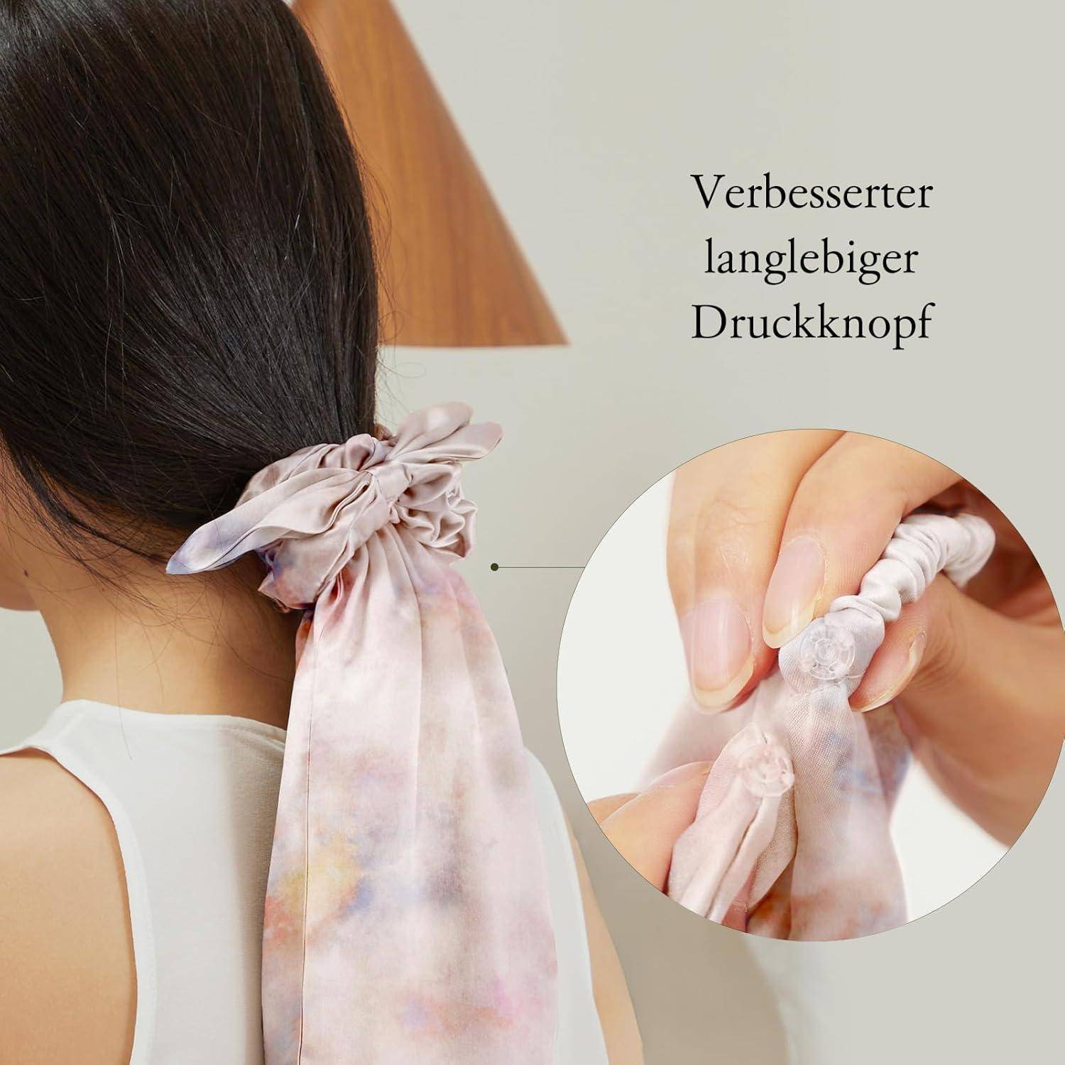 Eine Frau mit einem hellrosa Kopftuch, das hinten gebunden ist. Ein Einschub zeigt eine Hand, die einen robusten Druckknopf am Kopftuch befestigt. Deutscher Text liest sich: 