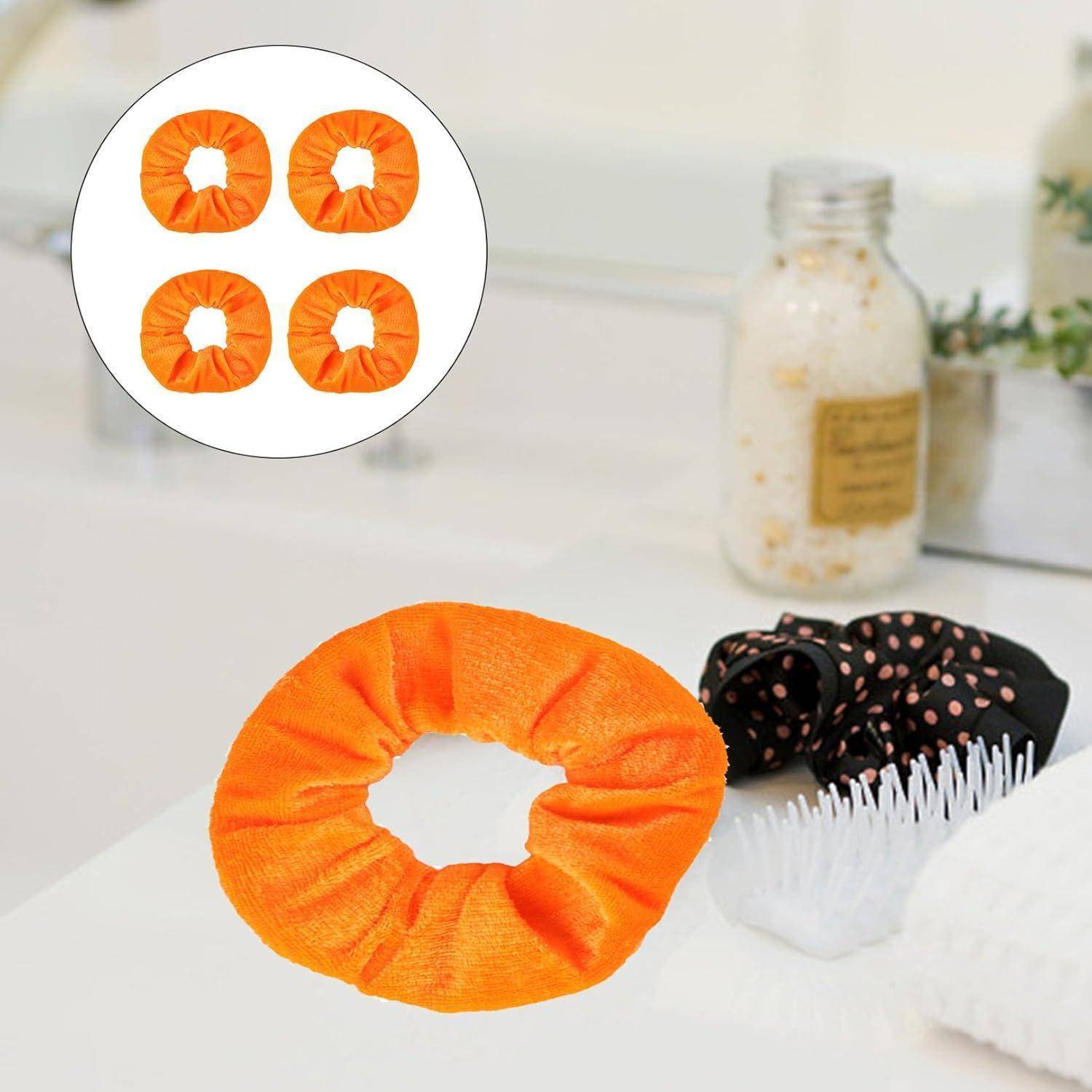 Orangefarbener Haargummi auf einer Badezimmerablage, in der Nähe von Hautpflegeprodukten und einem schwarzen Haarband mit pinken Punkten.