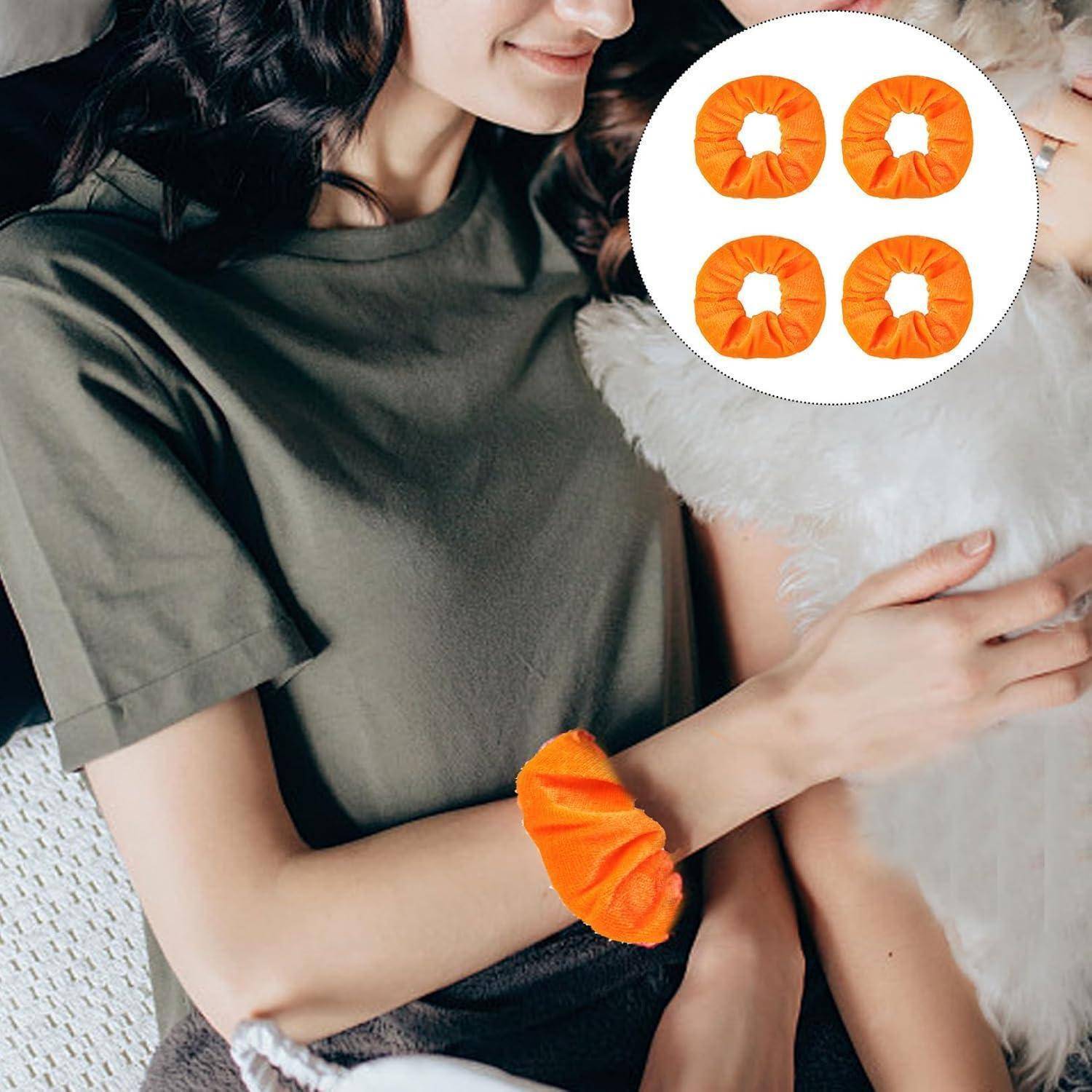 Eine Person mit einem grünen Shirt hält ein flauschiges weißes Haustier. Ein leuchtend orangefarbener Scrunchie befindet sich an ihrem Handgelenk, mit einer Detailansicht, die vier ähnliche Scrunchies zeigt.