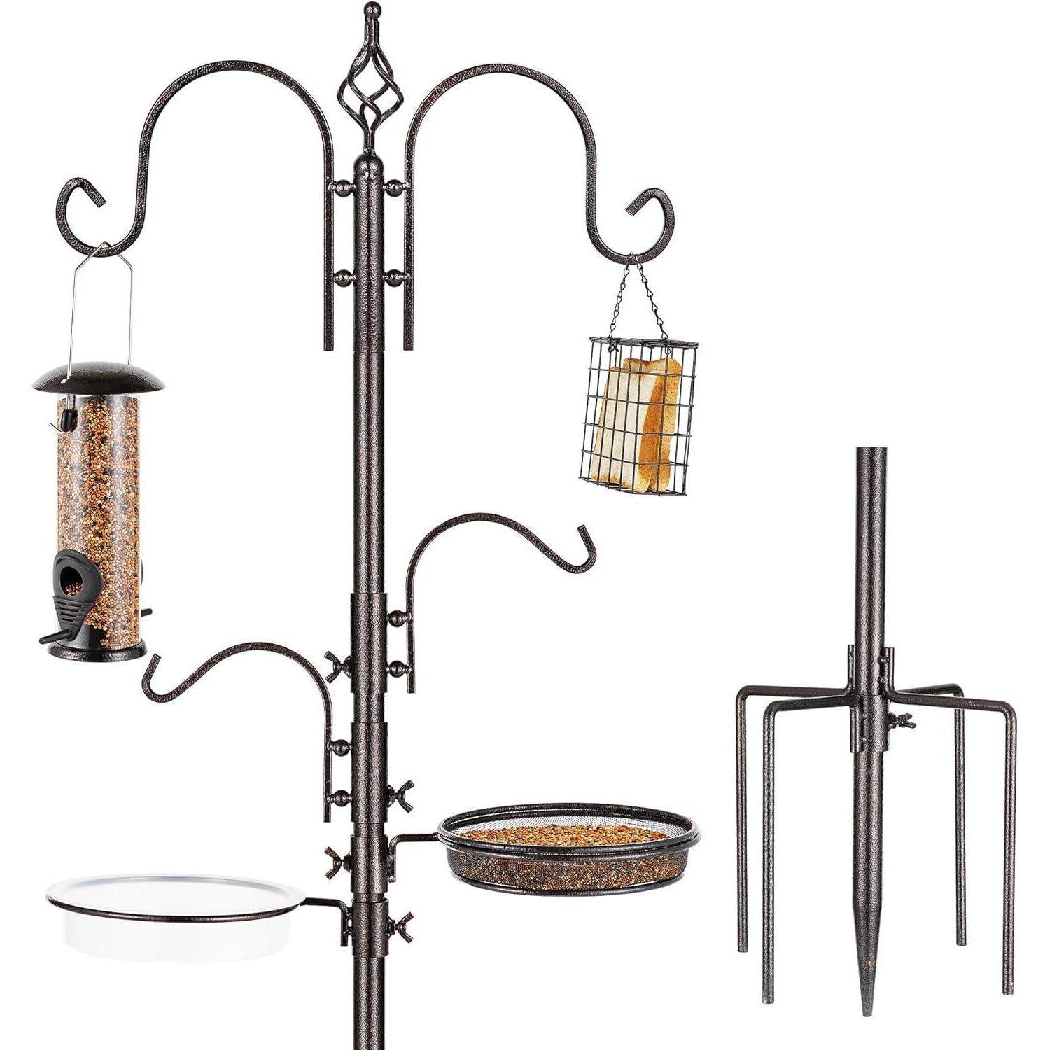 Schwarzer Metallvogelfutterständer mit mehreren Haken, an denen ein Samenspender, ein Suet-Käfig, eine Wasserschale und ein Tablett befestigt sind. Inklusive Erdpflock.