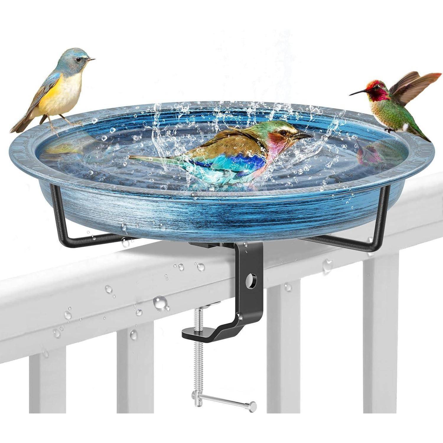 Vögel haben sich um und in einem blauen Metallvogelbadbecken versammelt, das mit Wasser gefüllt ist. Sie planschen und sitzen auf dessen Rand, das an einem Geländer befestigt ist.