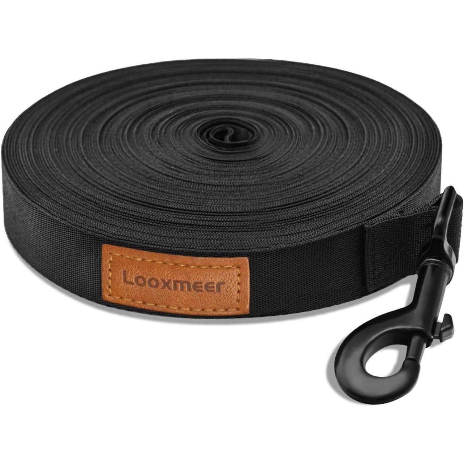 Eine aufgerollte schwarze Hundeleine mit einer bronzefarbenen Schnalle und einem braunen Etikett mit der Aufschrift 