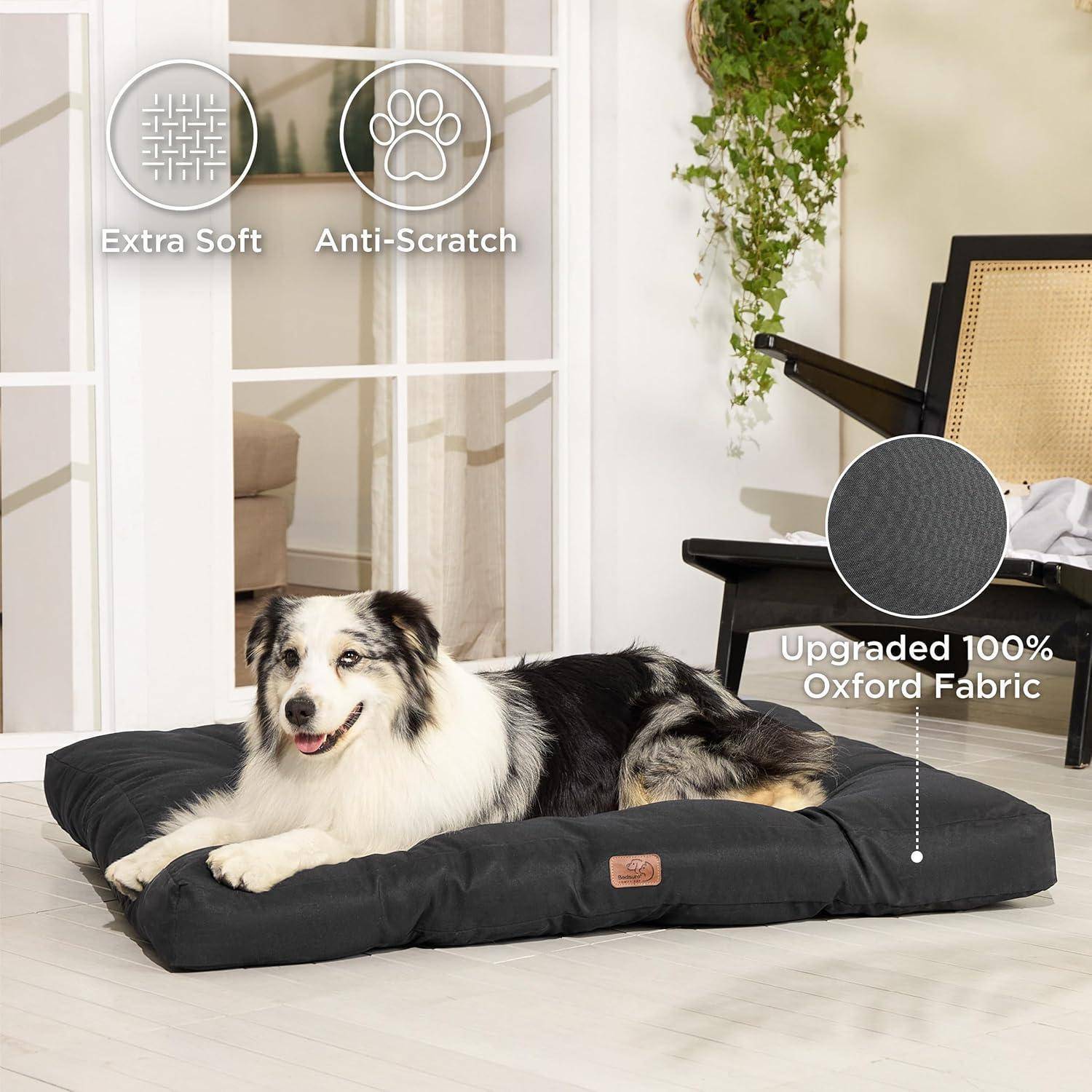 Ein schwarz-weißer Hund liegt auf einem weichen, schwarzen Bett in Innenräumen. Text lautet: 'Extra Weich', 'Kratzfest', 'Aufgewertet 100% Oxford-Stoff'.