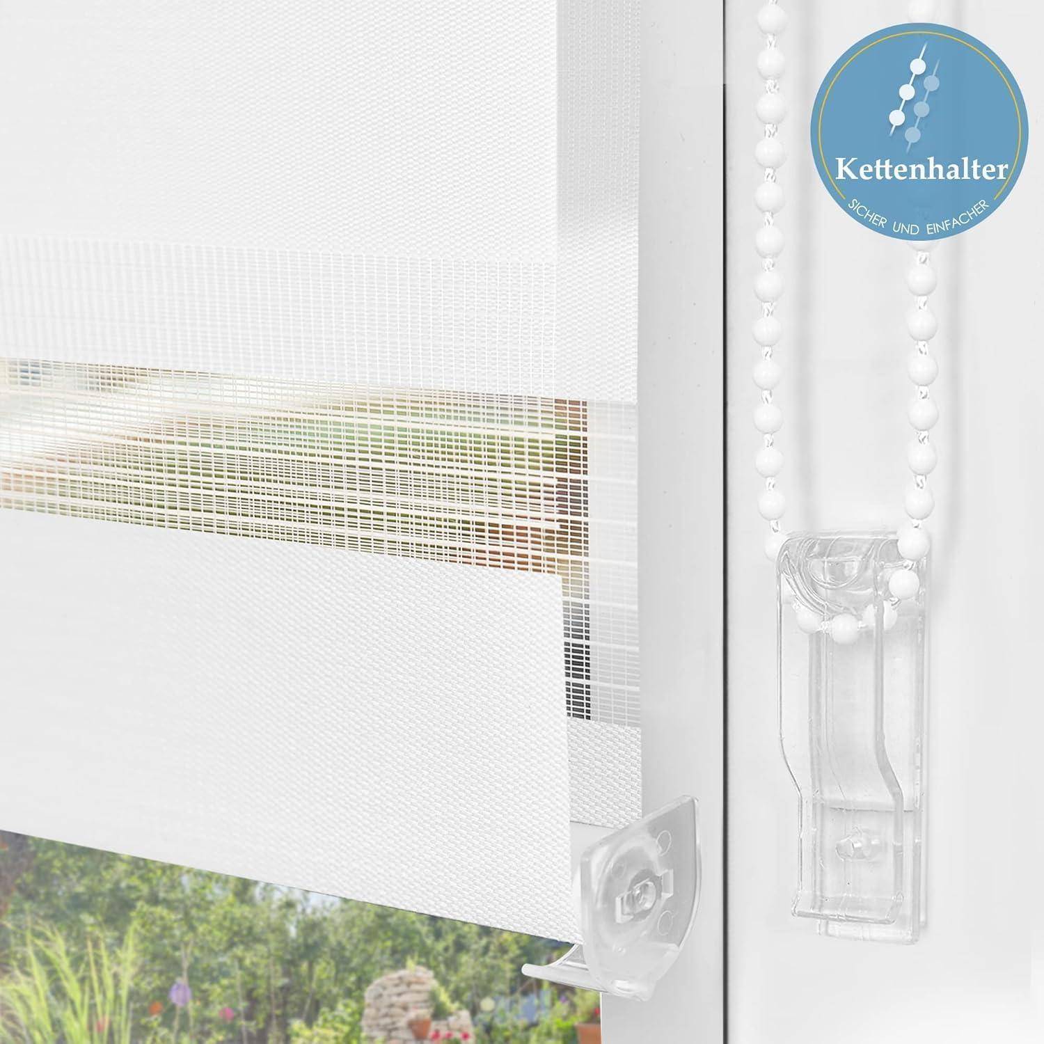 Ein weißer, durchscheinender Rollo mit einem durchsichtigen Kunststoff-Kettenhalter ist über einem Fenster installiert, das auf einen Garten hinausblickt.