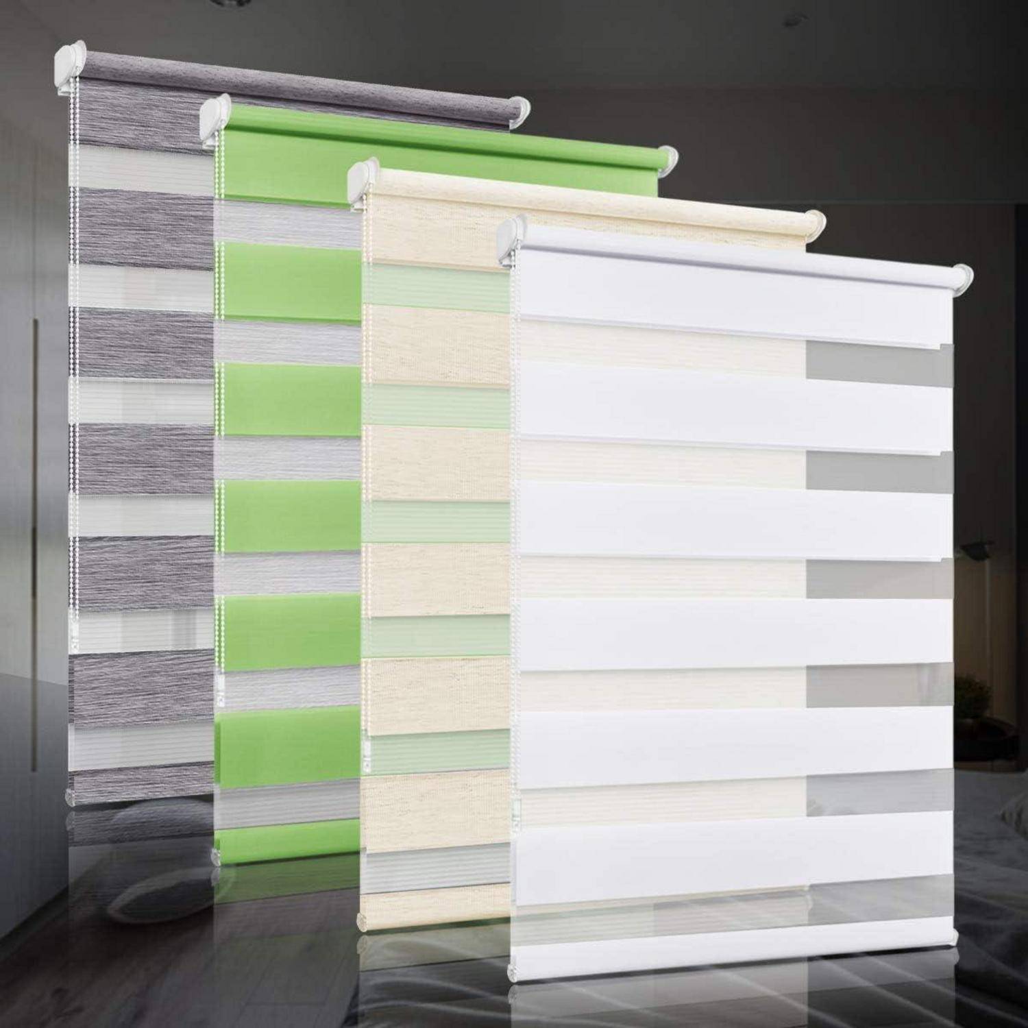 Drei Doppellagige Rollos in Grau, Grün und Beige, die auf einer reflektierenden Oberfläche ausgestellt sind. Jedes Rollo wechselt zwischen durchgehenden und transparenten Streifen.