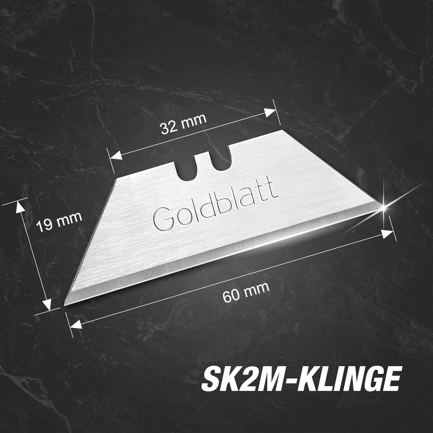 Eine silberne 'Goldblatt' Rasierklingen mit Maßen: 60 mm Länge, 32 mm Breite oben und 19 mm Breite an der unteren Kante. Gekennzeichnet mit 'SK2M-Klinge'.