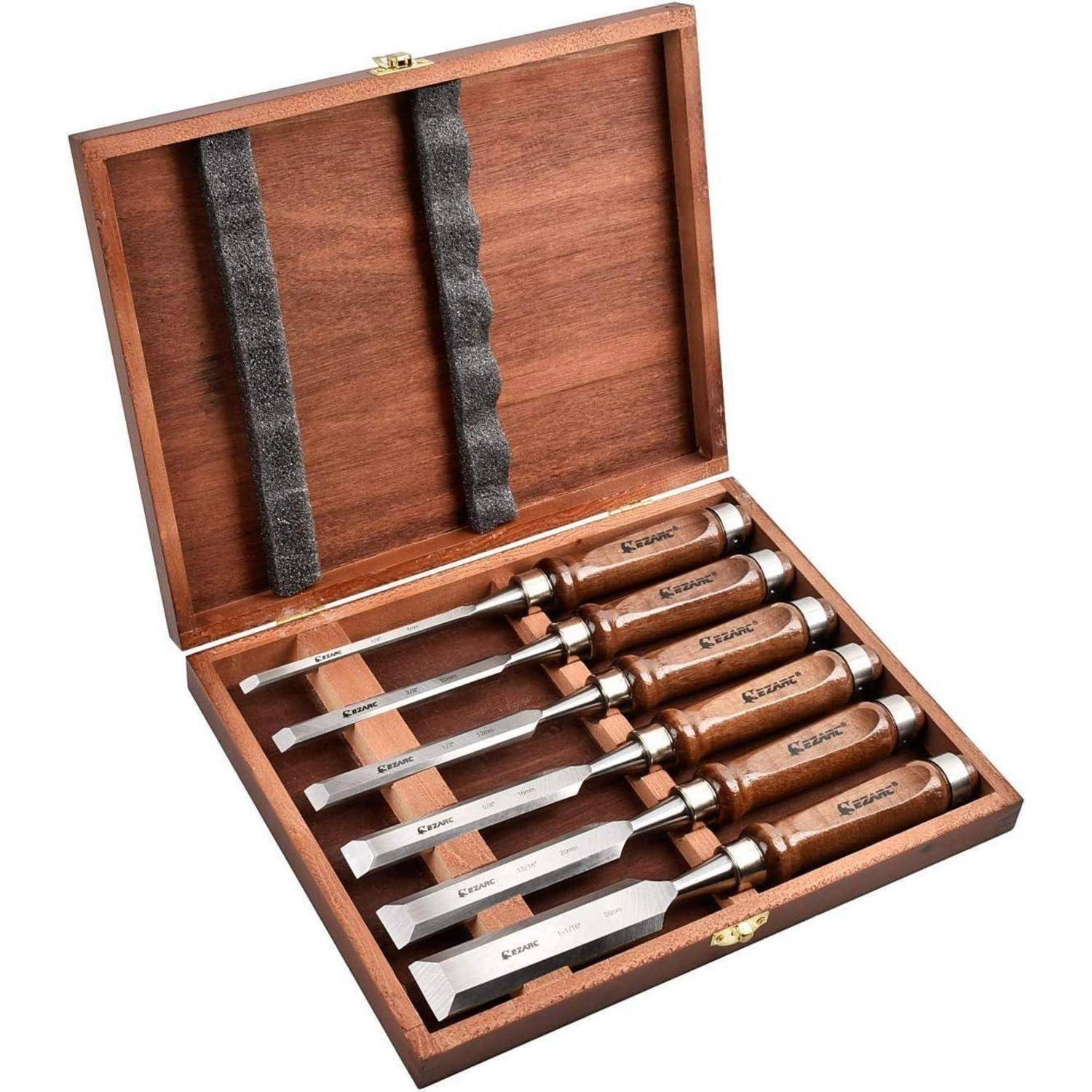 Eine Holzkiste, die sechs Meißel mit Holzgriffen enthält, die jeweils mit unterschiedlichen Größen beschriftet sind und für Holzarbeiten oder Schnitzaufgaben verwendet werden.