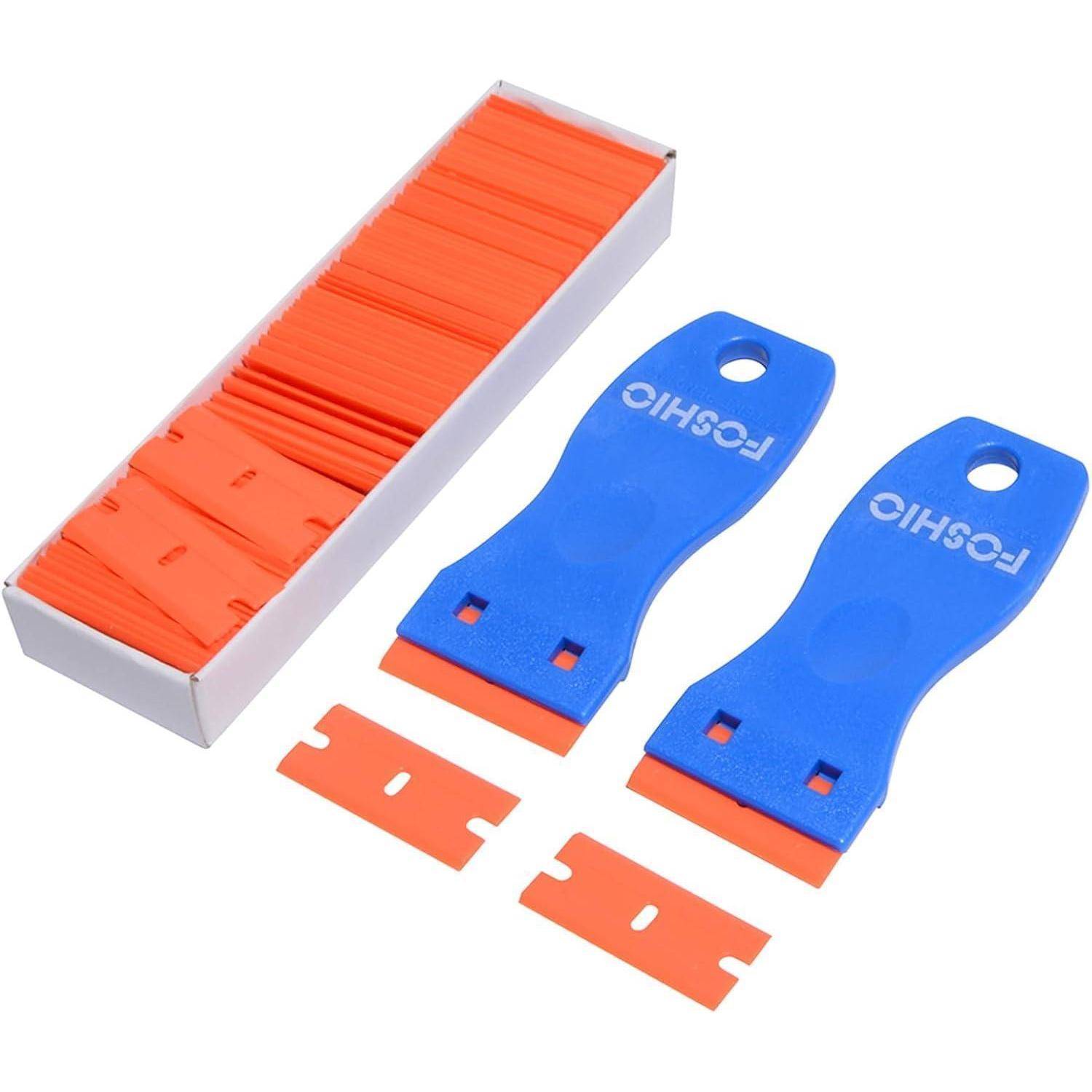 Eine blaue Werkzeugausrüstung mit zwei Kunststoffschabern und mehreren orangefarbenen Klingen, entwickelt für das sichere Entfernen von Aufklebern oder Dekalen ohne Oberflächen zu zerkratzen.