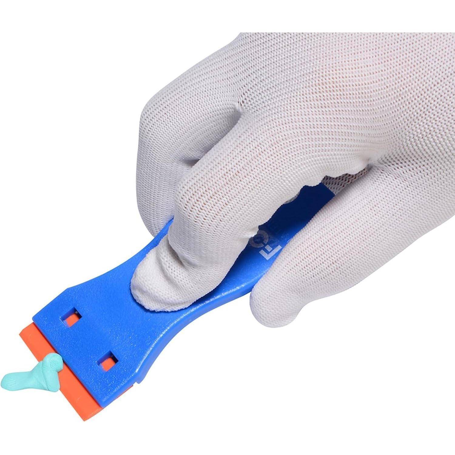 Eine Handschuh tragende Hand hält ein blaues Werkzeug und schabt eine kleine Menge hellblaues Material von einer Oberfläche.