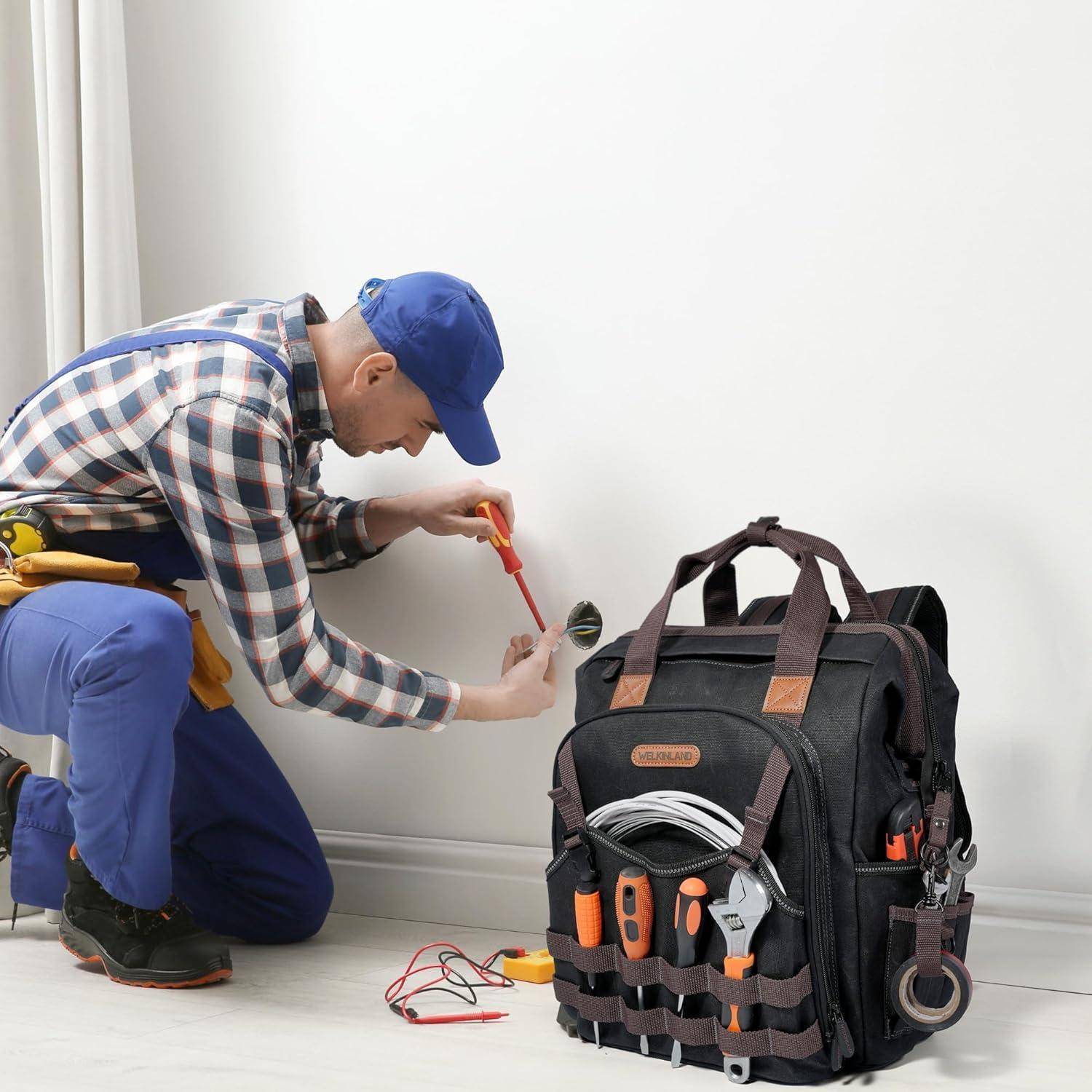 Eine Person in Arbeitskleidung hockt und behebt ein elektrisches Problem mit Werkzeugen in der Hand. Eine Werkzeugtasche liegt in der Nähe und ist mit verschiedenen Instrumenten gefüllt.