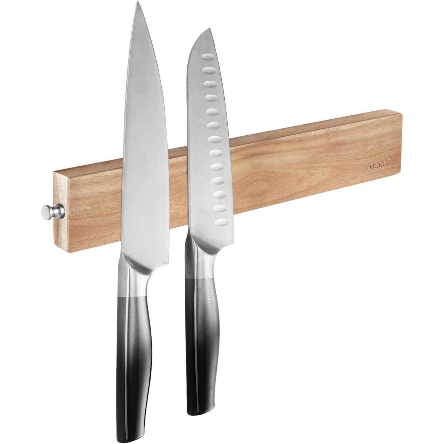 Zwei Küchenmesser mit schwarzen Griffen sind magnetisch an einem Holzstreifen an der Wand befestigt.