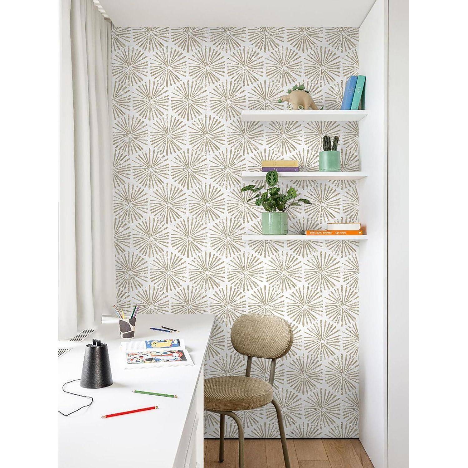 Eine minimalistische Arbeitsecke mit gemusterter Wand, einem Schreibtisch mit Schreibutensilien, einem beigen Stuhl und Wandregalen, auf denen Dekorationsgegenstände und Bücher stehen.