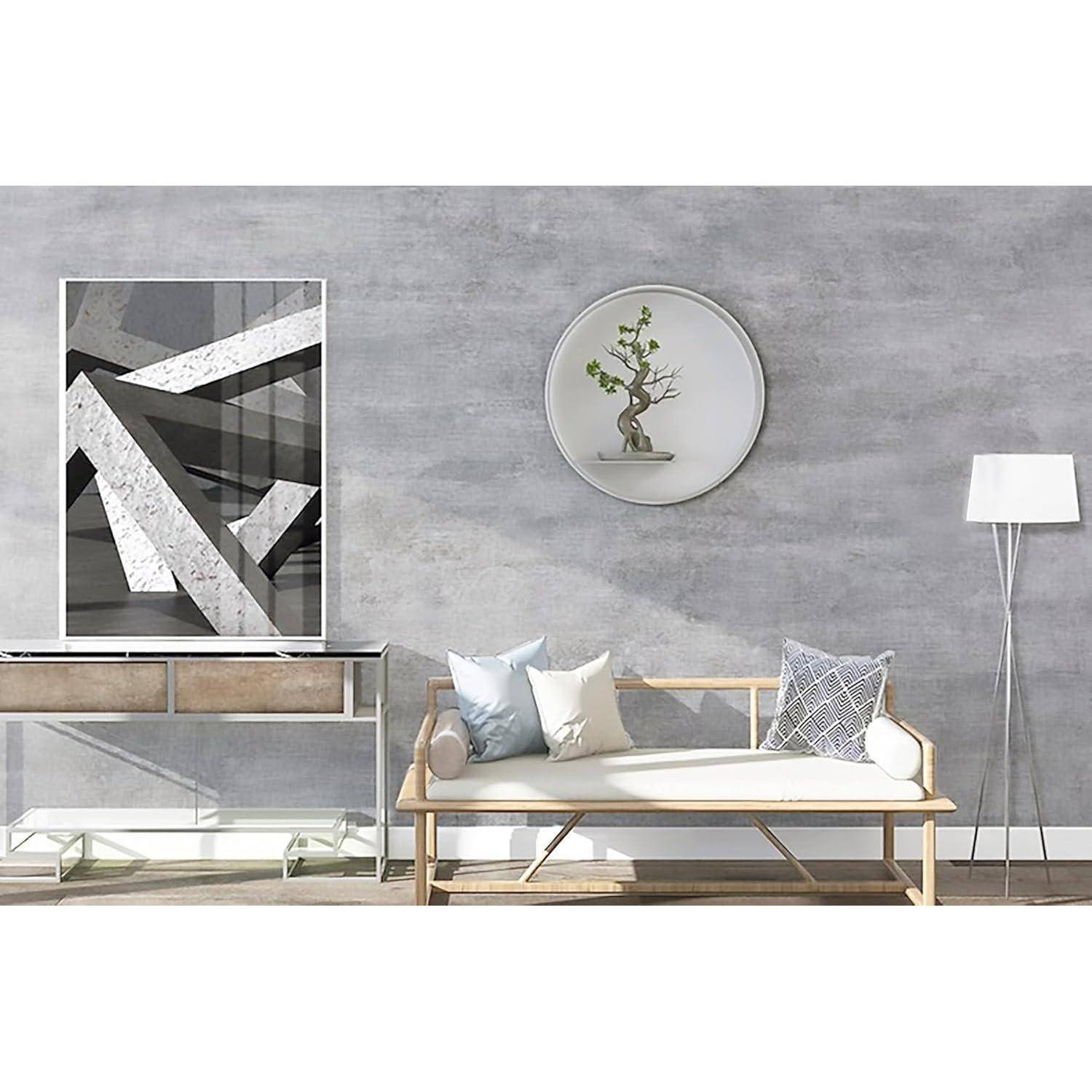 Ein minimalistisches Wohnzimmer mit einer hellen Holzbank und Kissen, einem geometrischen Kunstwerk, einem Bonsai in einem Wandrahmen und einer Stehlampe.