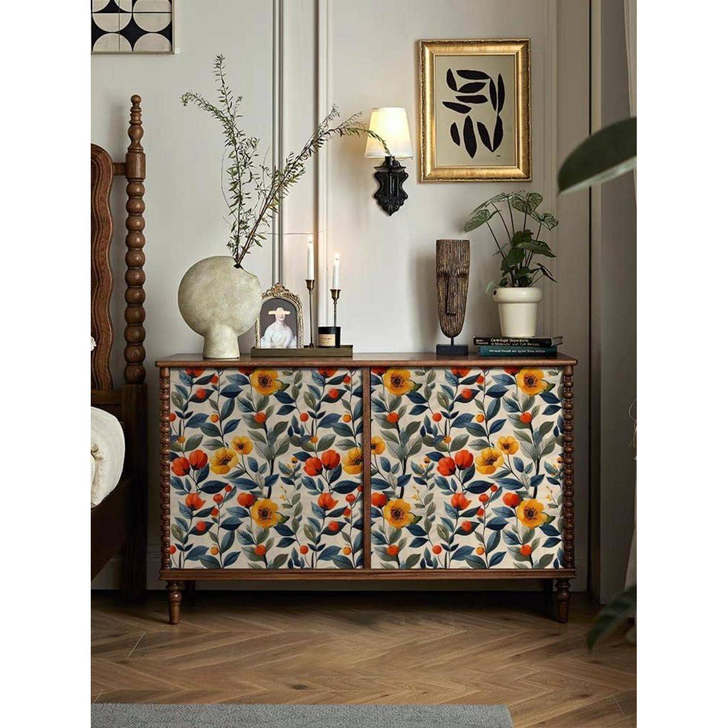 Ein Dekorationsschrank in einem Raum mit lebhaften Blumenmustern aus orangen und gelben Blumen, der neben einem Bett steht.