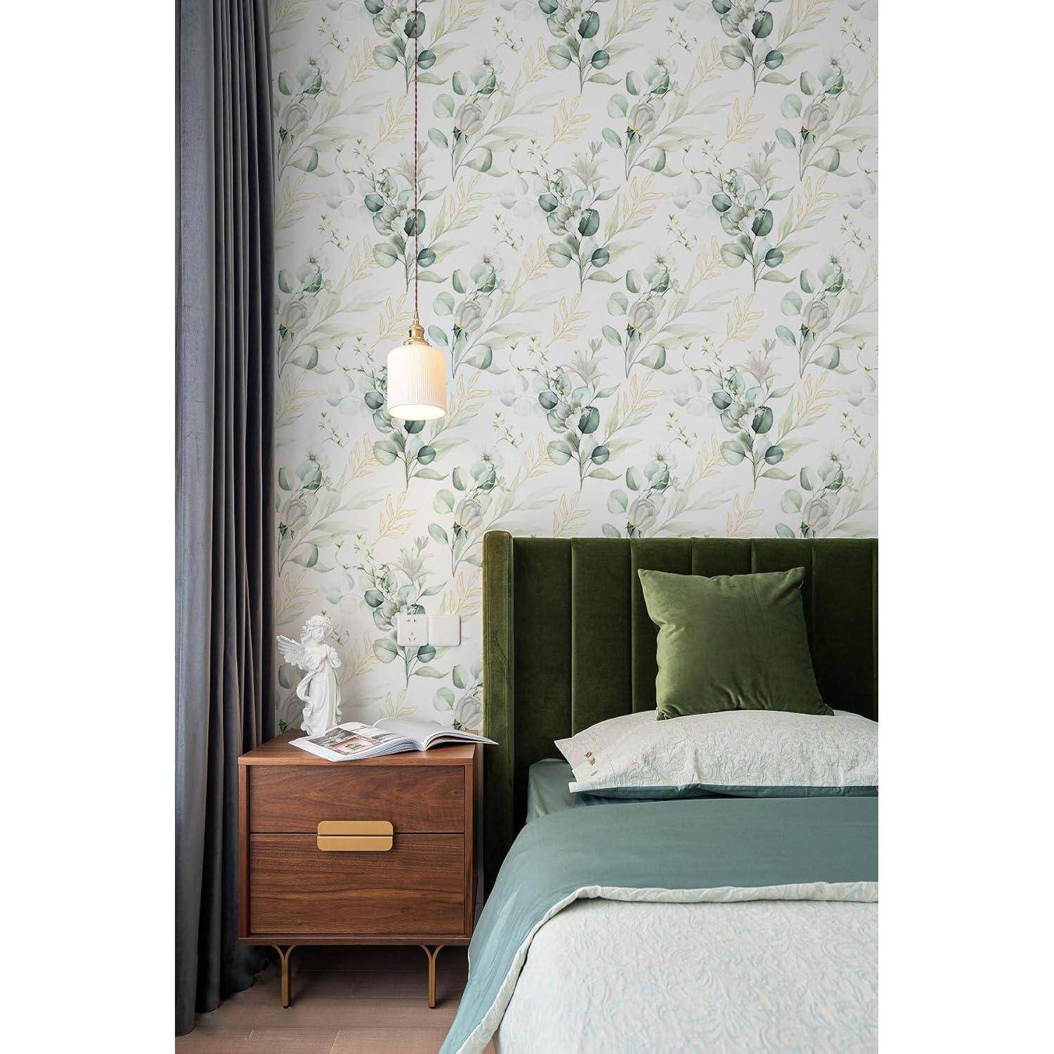 Schlafzimmer mit grünem Samtkopfteil, Tapete mit Blumenmuster und einem Holznachttisch mit Dekorationselementen.