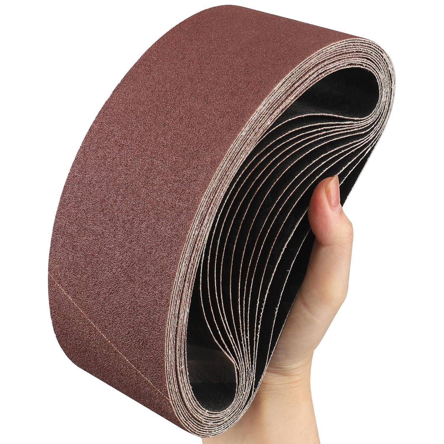 Eine Hand hält eine Rolle brauner Schleifpapierstreifen, was andeutet, dass das Material flexibel ist und bereit für Schleifaufgaben oder Holzarbeiten.