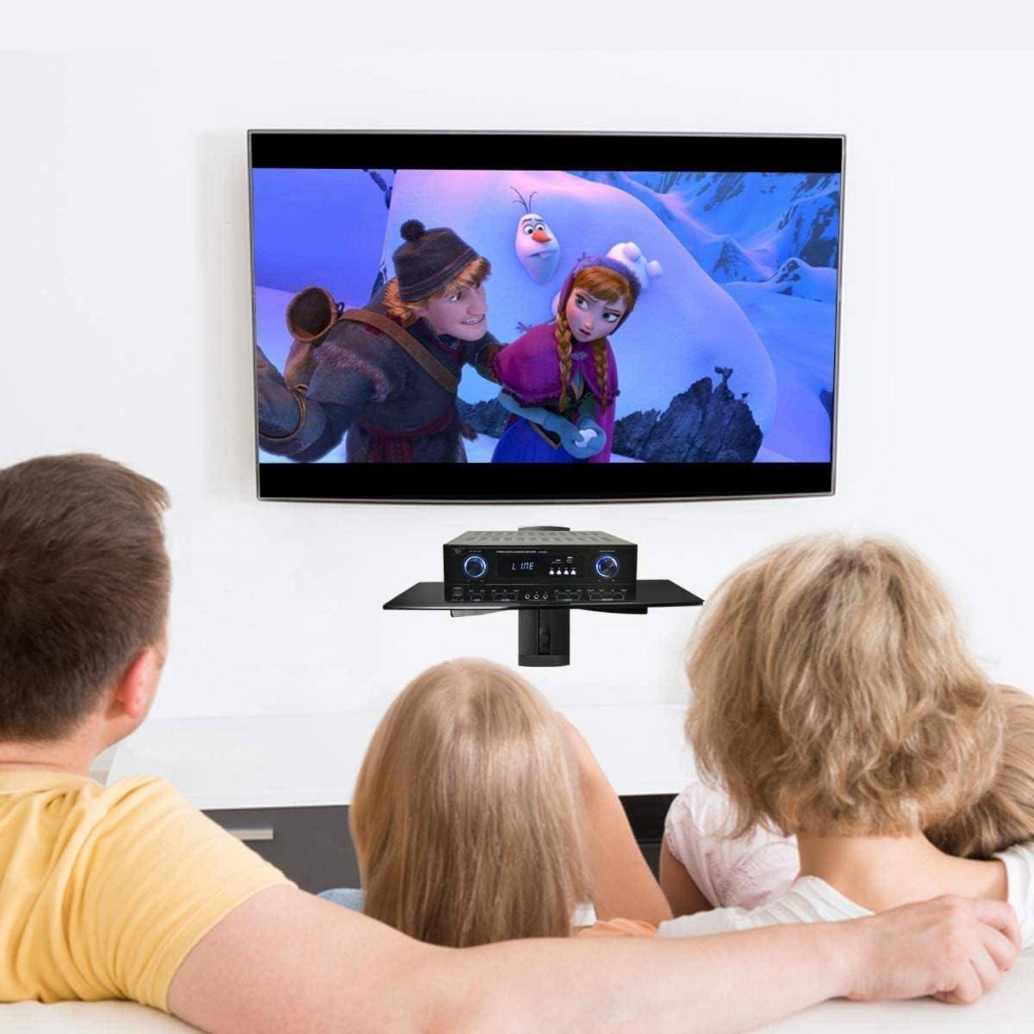 Eine vierköpfige Familie schaut einen Animationsfilm mit zwei Charakteren in verschneiten Bergen auf einem modernen Fernseher, der an der Wand montiert ist.