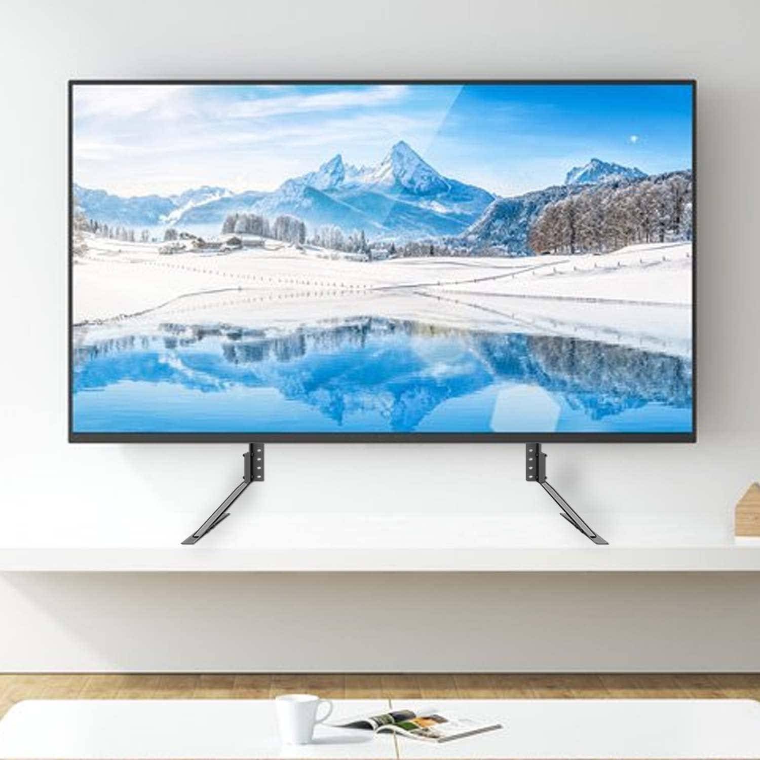 Ein Flachbildfernseher, der eine verschneite Berglandschaft mit Seespiegelung zeigt. Der Fernseher ist an einer minimalistischen weißen Wand montiert.