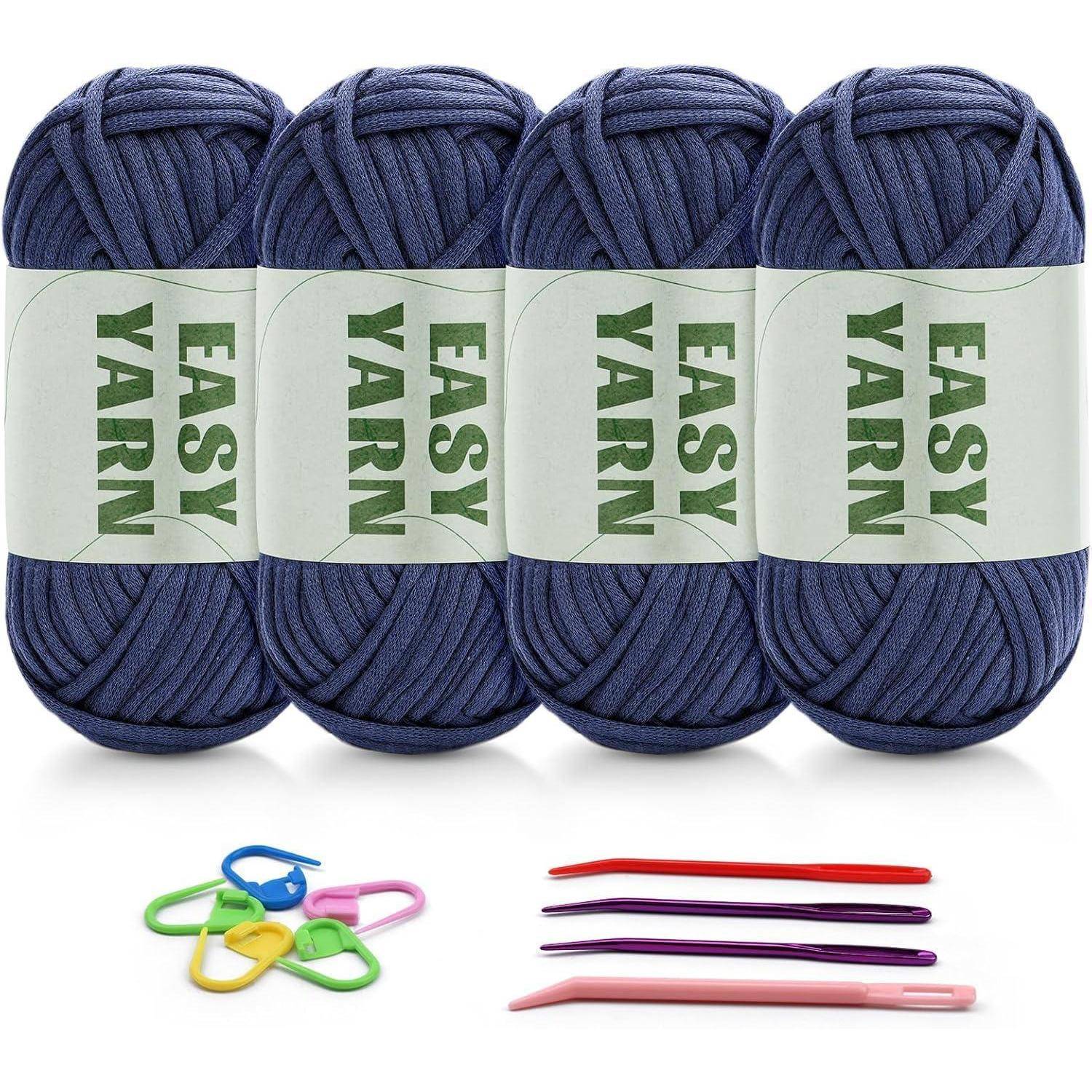 Vier Knäuel blaues 'Easy Yarn' mit Häkelnadeln und Maschenmarkierern darunter, was ein Häkel-Set andeutet.