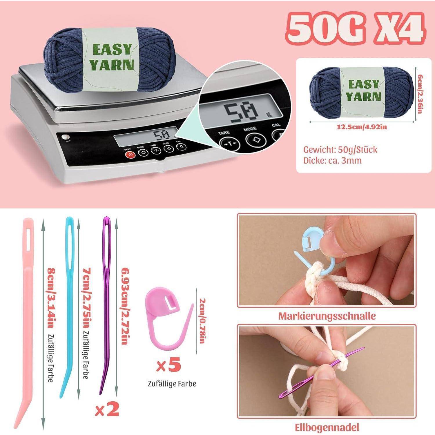 Eine digitale Waage, die '50g' anzeigt, misst Bündel von violetter Wolle, die mit 'Easy Yarn' beschriftet sind, mit Strickutensilien und Nadeln daneben.