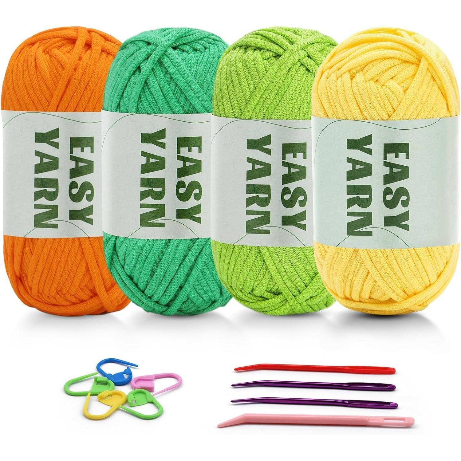 Vier Wollknäuel in Orange, Blau, Grün und Gelb, beschriftet mit 
