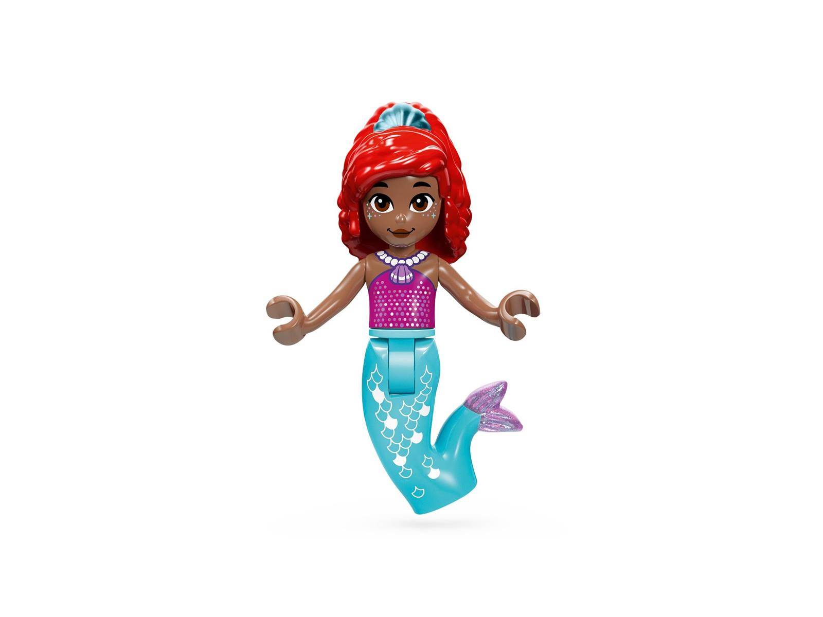 Eine kleine Meerjungfrau-Spielfigur mit roten Haaren, rosafarbenem Oberteil und türkisfarbenem Schwanz auf weißem Hintergrund.