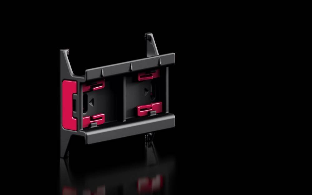 Ein rot-schwarzer Smartphone-Halter mit Clips, der für die Nutzung im Auto entwickelt wurde. Er verfügt über eine verstellbare Basis, die sich an verschiedene Telefongrößen anpassen lässt.