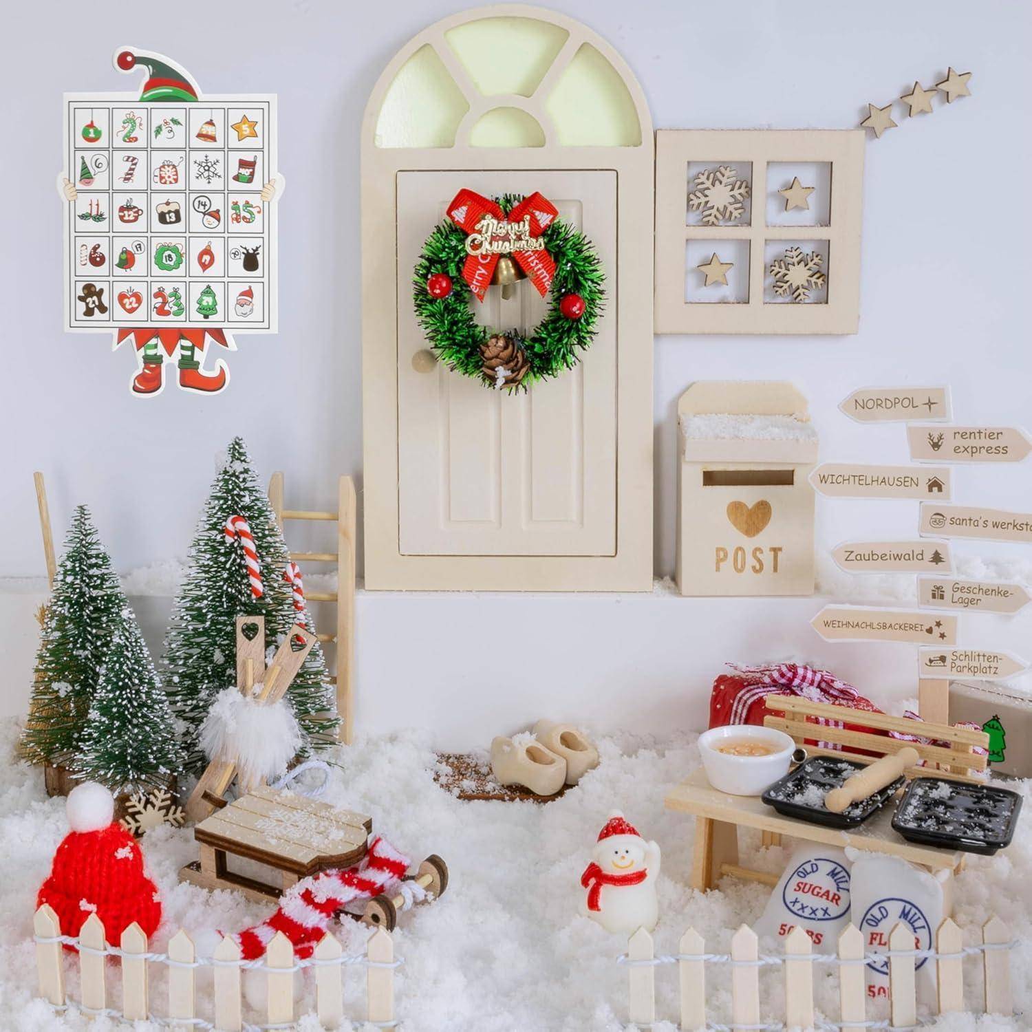 Eine festliche Miniatur-Weihnachtsszene mit einer geschmückten Tür, einem Kranz, Bäumen, einem Schneemann, einem Schlitten und Schildern zu verschiedenen winterlichen Orten.