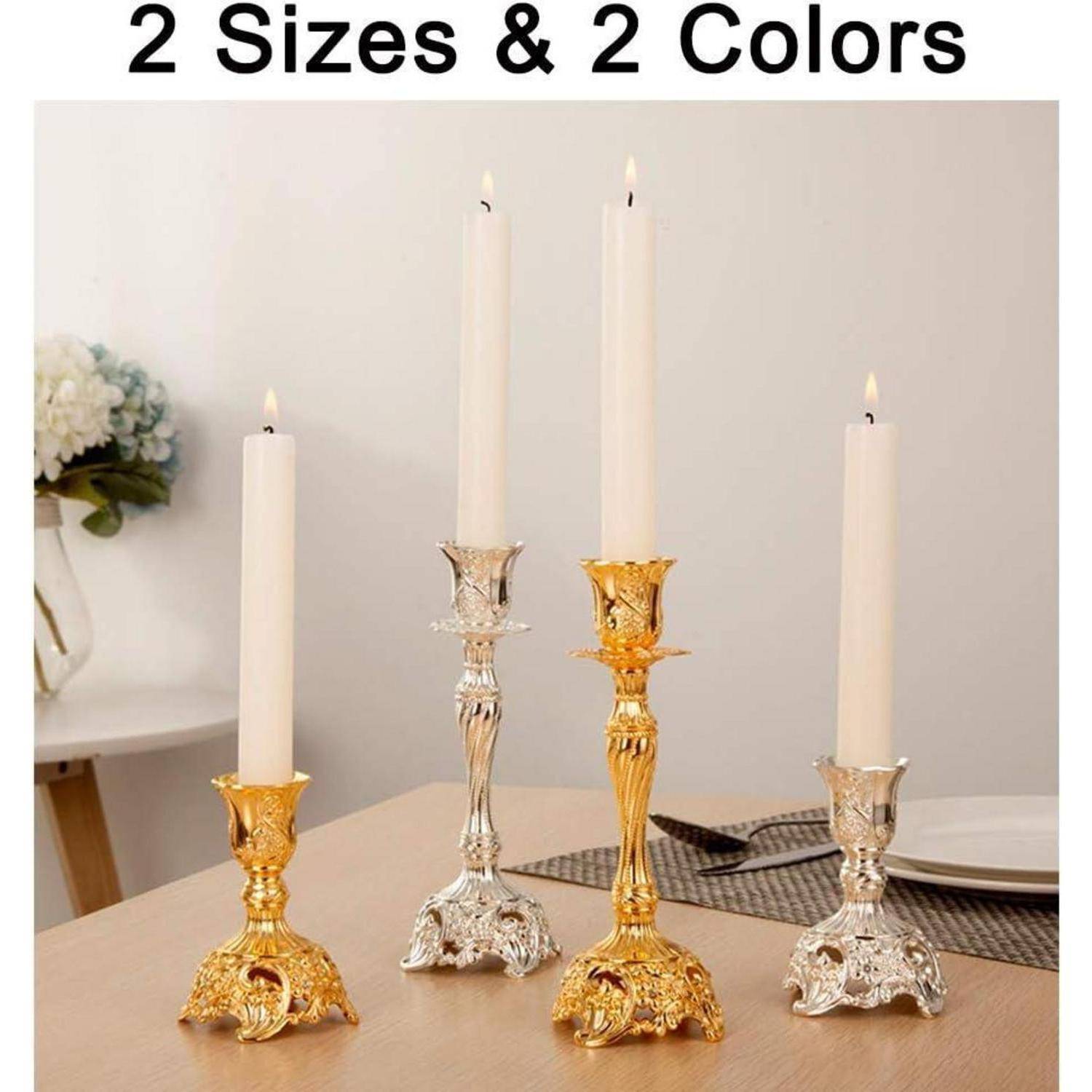 Vier kunstvoll gearbeitete Kerzenhalter sind auf einem Tisch ausgestellt, zwei in Gold und zwei in Silber, wobei jeder einen brennenden weißen Kerzenhalter trägt.