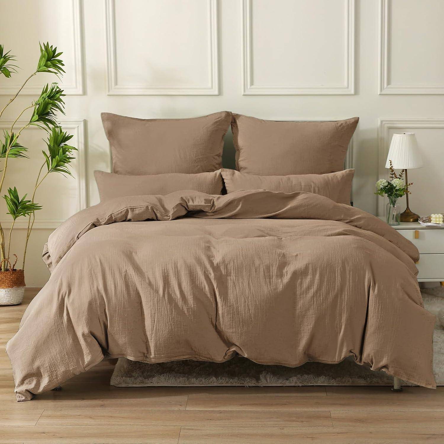 Ein ordentlich gemachtes Bett mit einer beigen Bettdecke und Kissen, platziert in einem modernen Schlafzimmer mit Holzboden und dekorativen Pflanzen.
