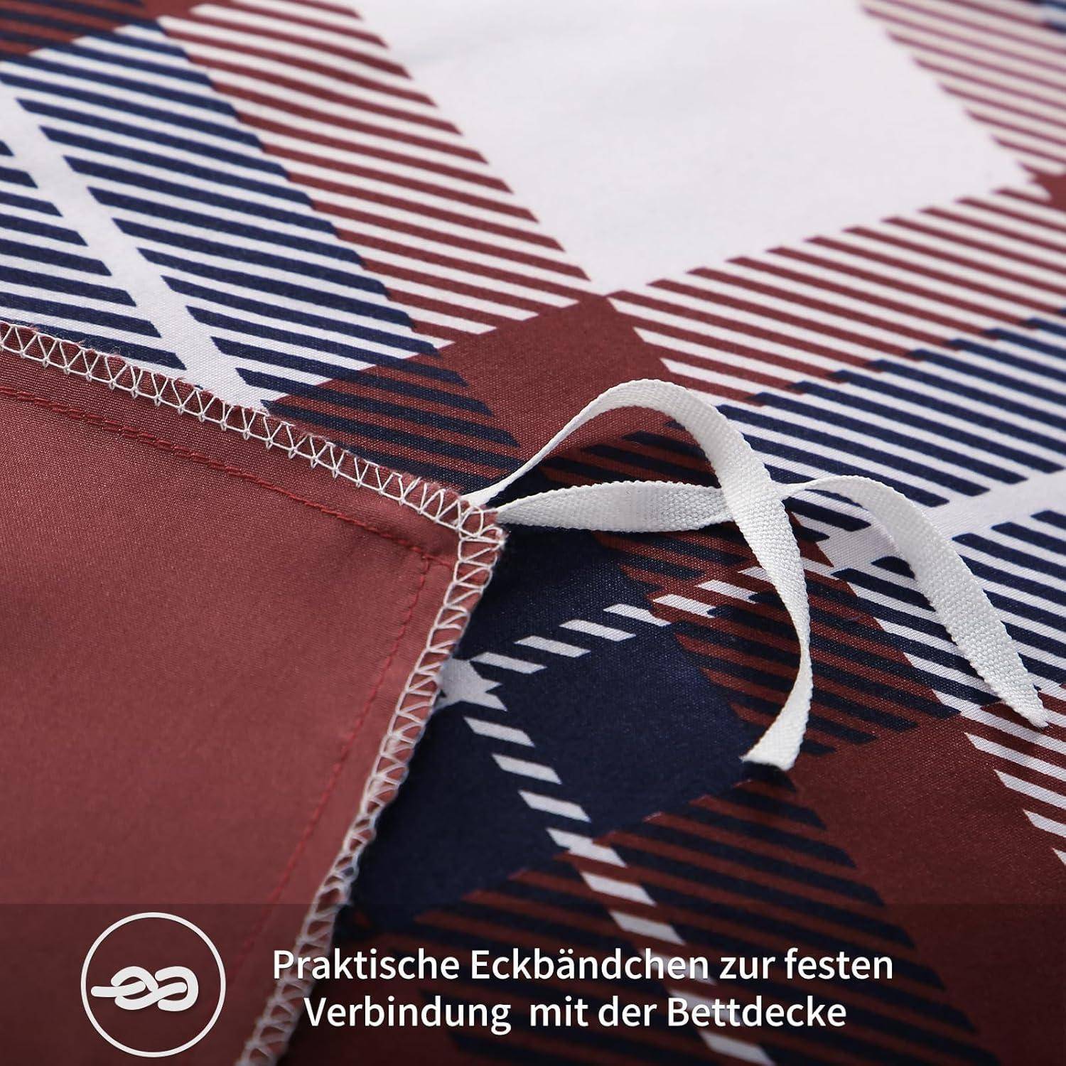 Nahaufnahme eines Stoffes mit diagonalen marineblau-roten Streifen, die einen genähten Rand und eine weiße Bindung zeigen. Text am unteren Rand liest: 'Praktische Eckbändchen zur festen Verbindung mit der Bettdecke'.