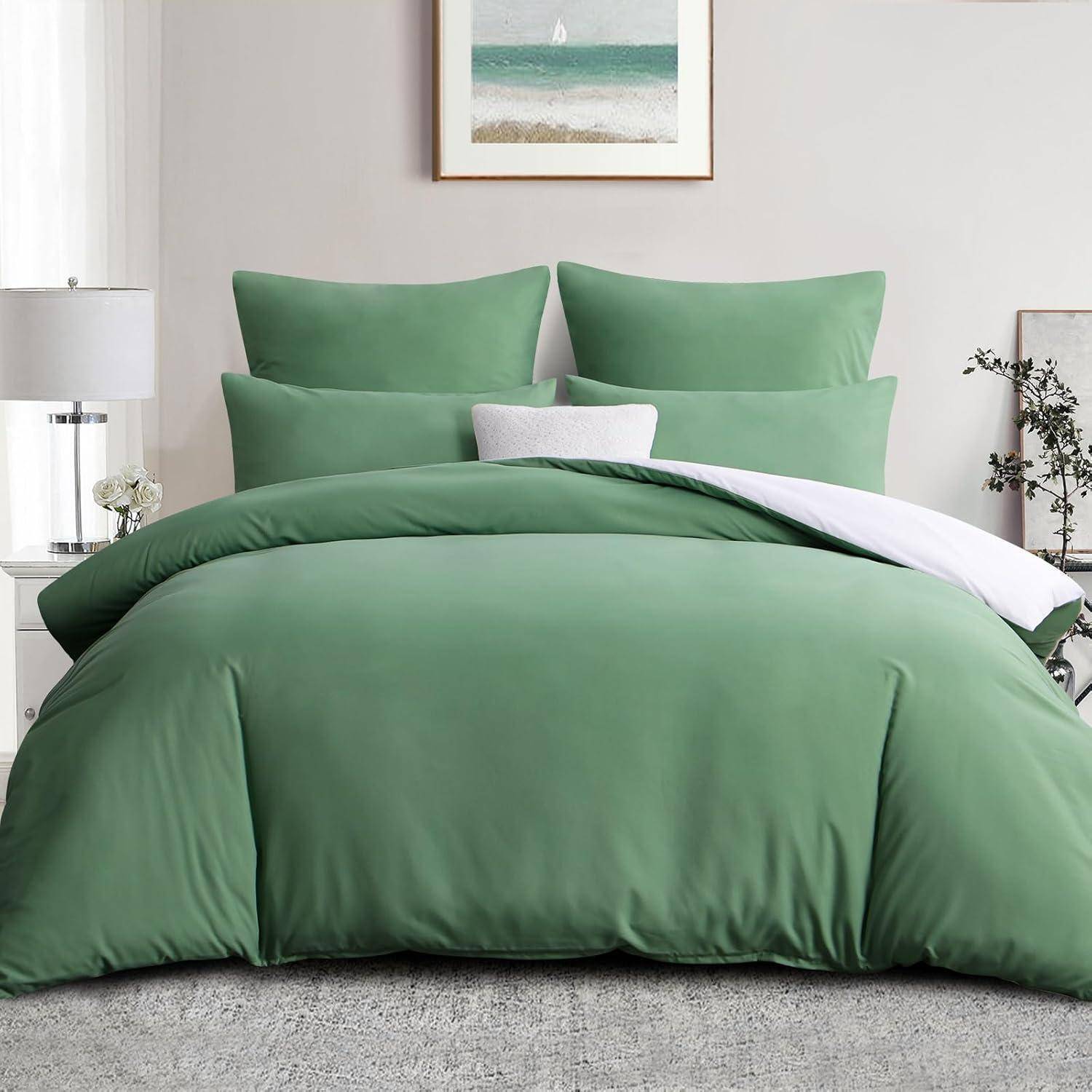 Ein ordentlich gemachtes Bett mit grüner Bettwäsche, zwei Kissen und einem gerahmten Oceanbild darüber. Eine kleine Pflanze und eine Lampe stehen auf den Nachttischen.