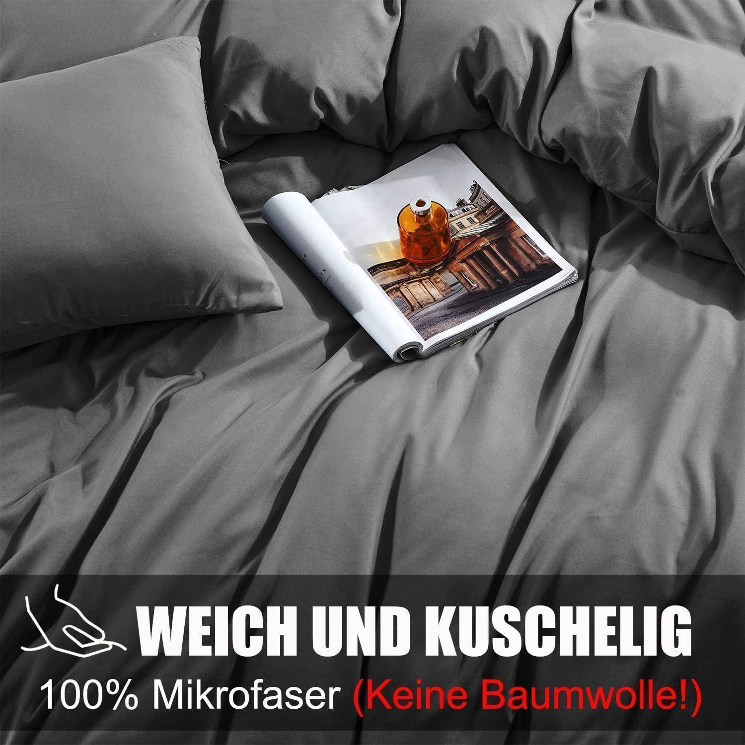 Ein gemütliches Bett mit einer grauen Mikrofaser-Bettdecke und Kissen. Ein Buch und eine Tasse befinden sich auf dem Bett. Text am unteren Rand lautet: „weich und kuschelig