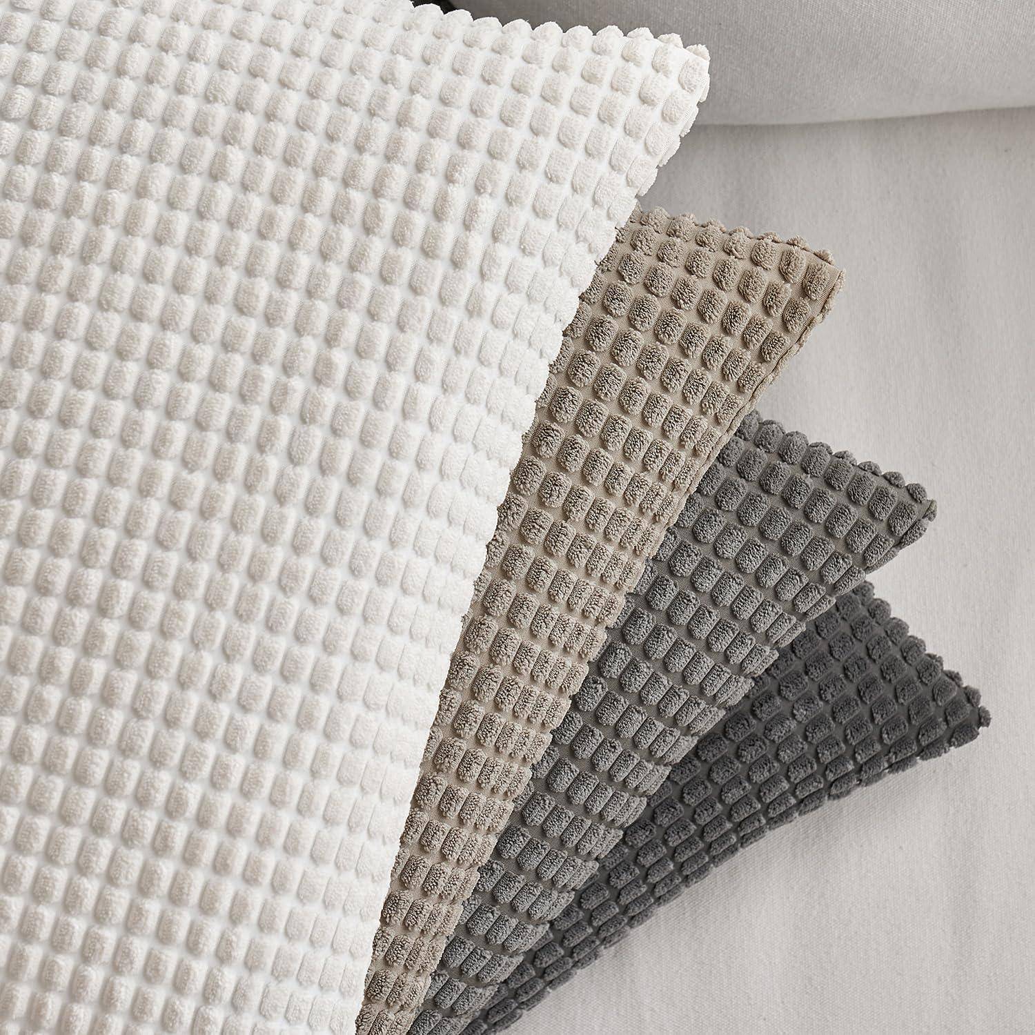 Vier Waffelpillen in Weiß, Beige, Grau und Dunkelgrau sind ordentlich gestapelt und zeigen einen Farbverlauf von hellen zu dunklen Tönen.