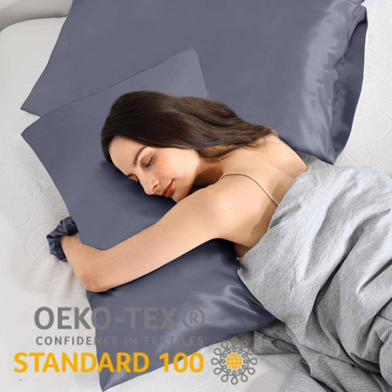 Eine Frau schläft gemütlich auf einem Bett mit dunklen grauen Satin-Laken. Die Bettwäsche ist als OEKO-TEX zertifiziert und weist damit auf die Textilsicherheit hin.