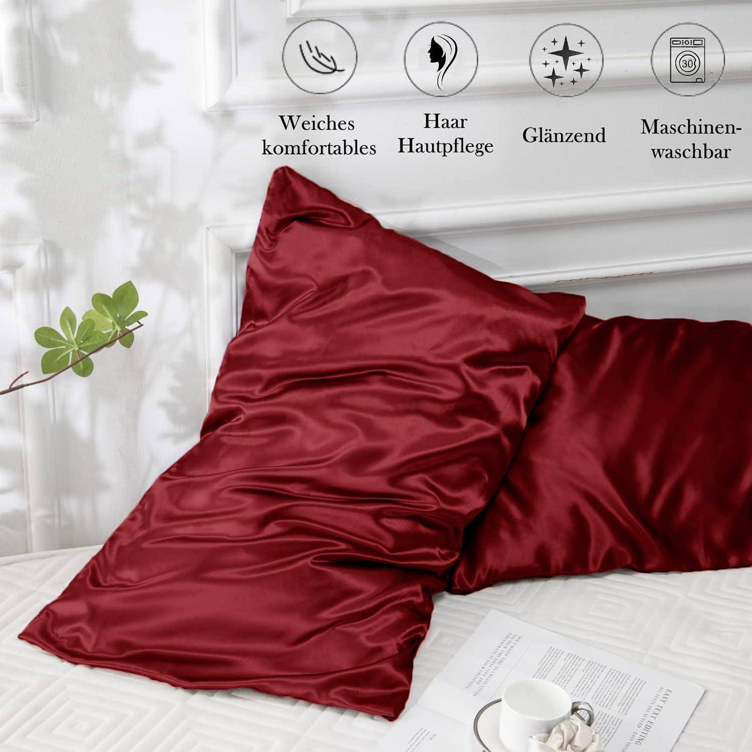 Rote Satin-Kissenbezüge auf einem Bett mit Symbolen und Text, die anzeigen, dass sie weich, bequem, haar-pflegend und maschinell waschbar sind.