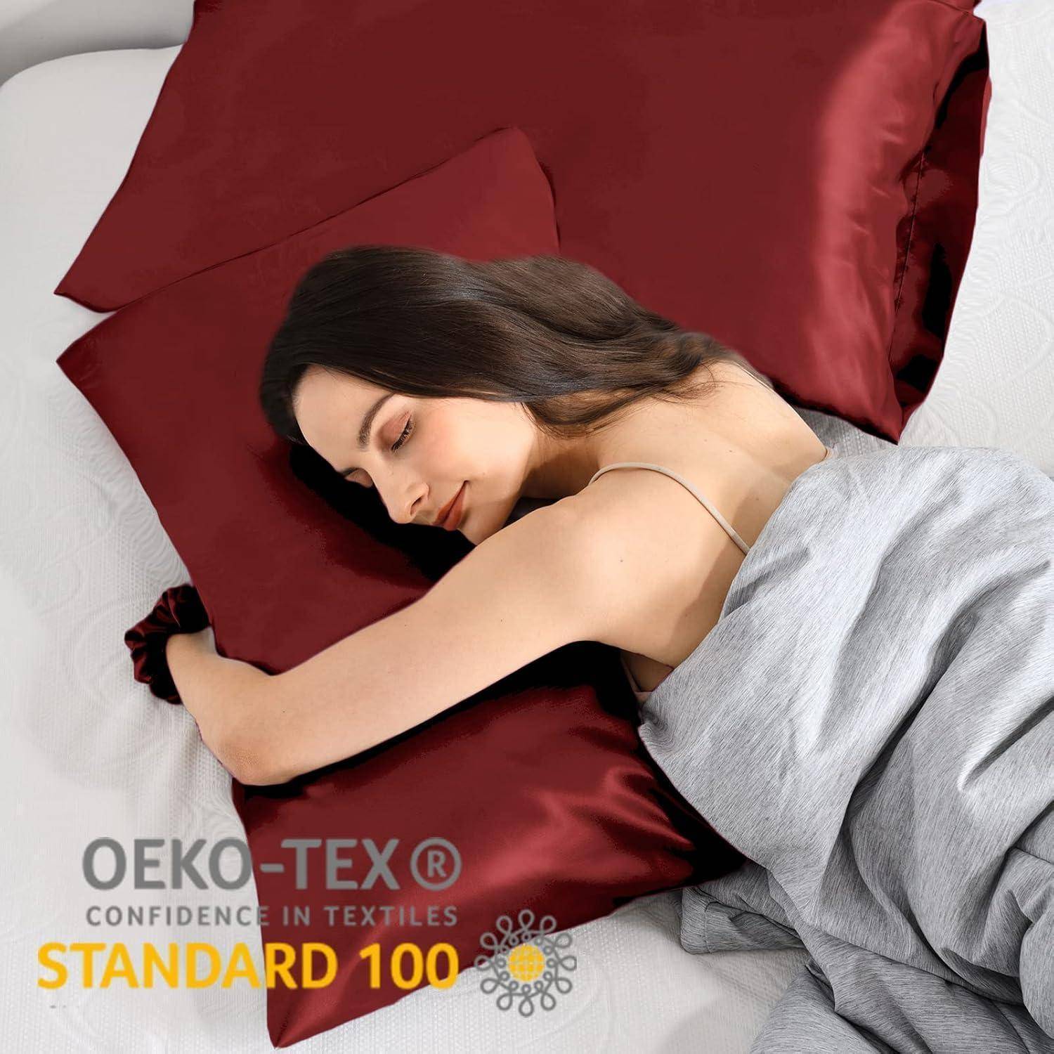 Eine Person schläft auf roten Seidenkissenbezügen mit einem 'OEKO-TEX Standard 100' Etikett, was darauf hinweist, dass der Stoff auf schädliche Substanzen getestet wurde.